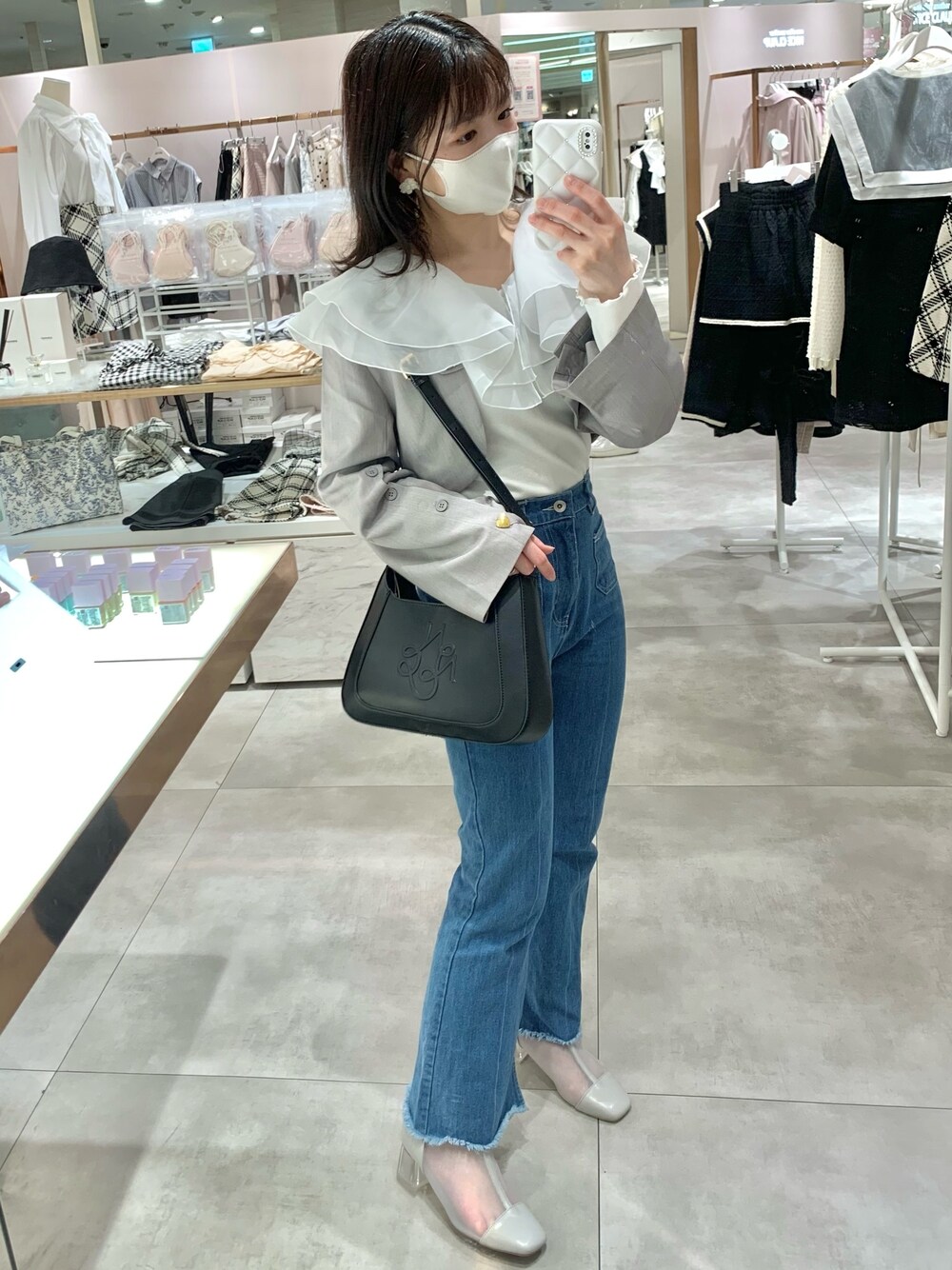 イエロー系のショルダーバッグ、ブルー系のデニムパンツ、グレー系のブーツを着用したレディースの春コーディネートの1枚目の写真