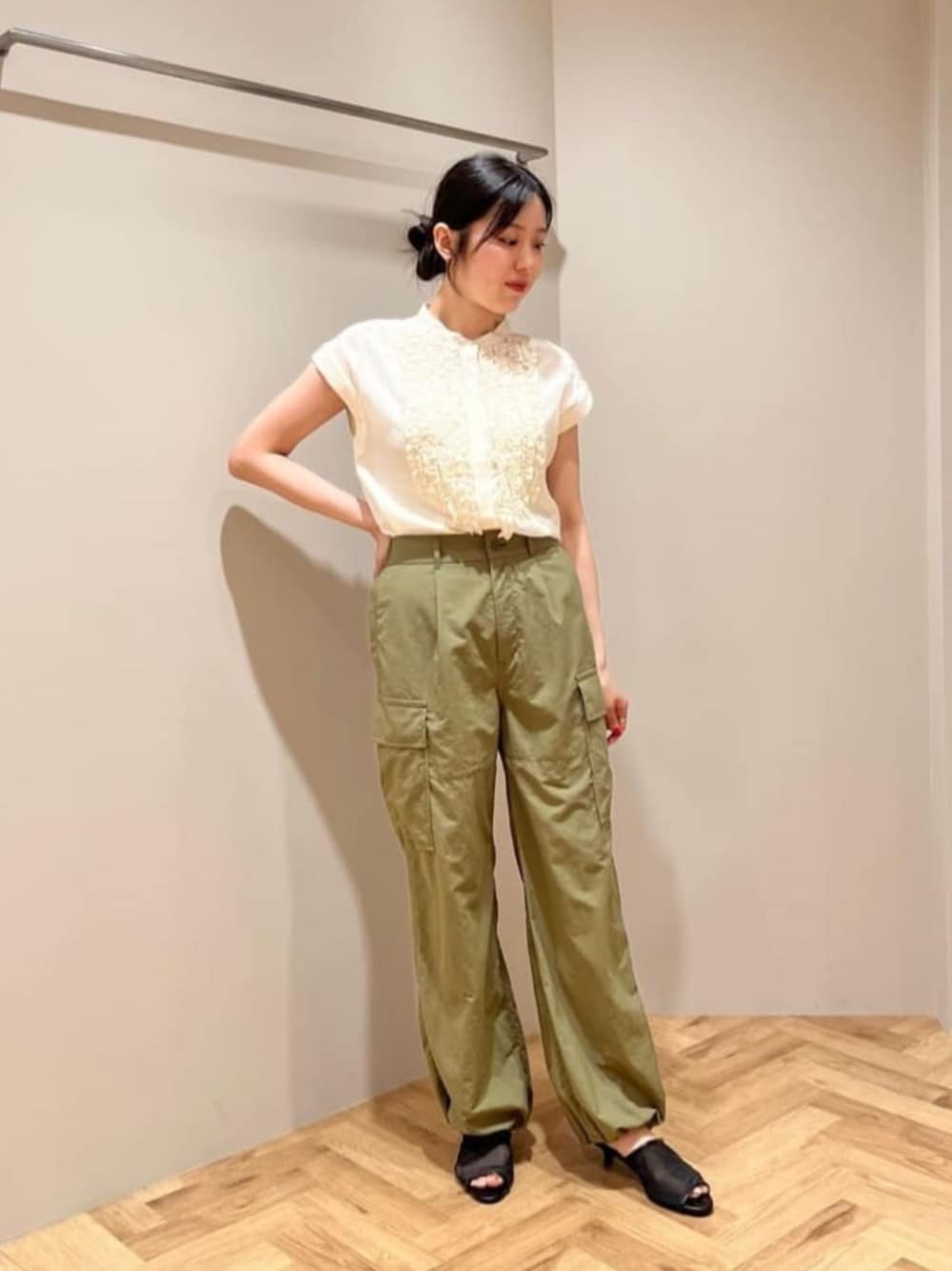 グリーン系のカーゴパンツ、ブラック系のサンダル、ホワイト系のシャツ/ブラウスを着用したレディースの春コーディネートの1枚目の写真