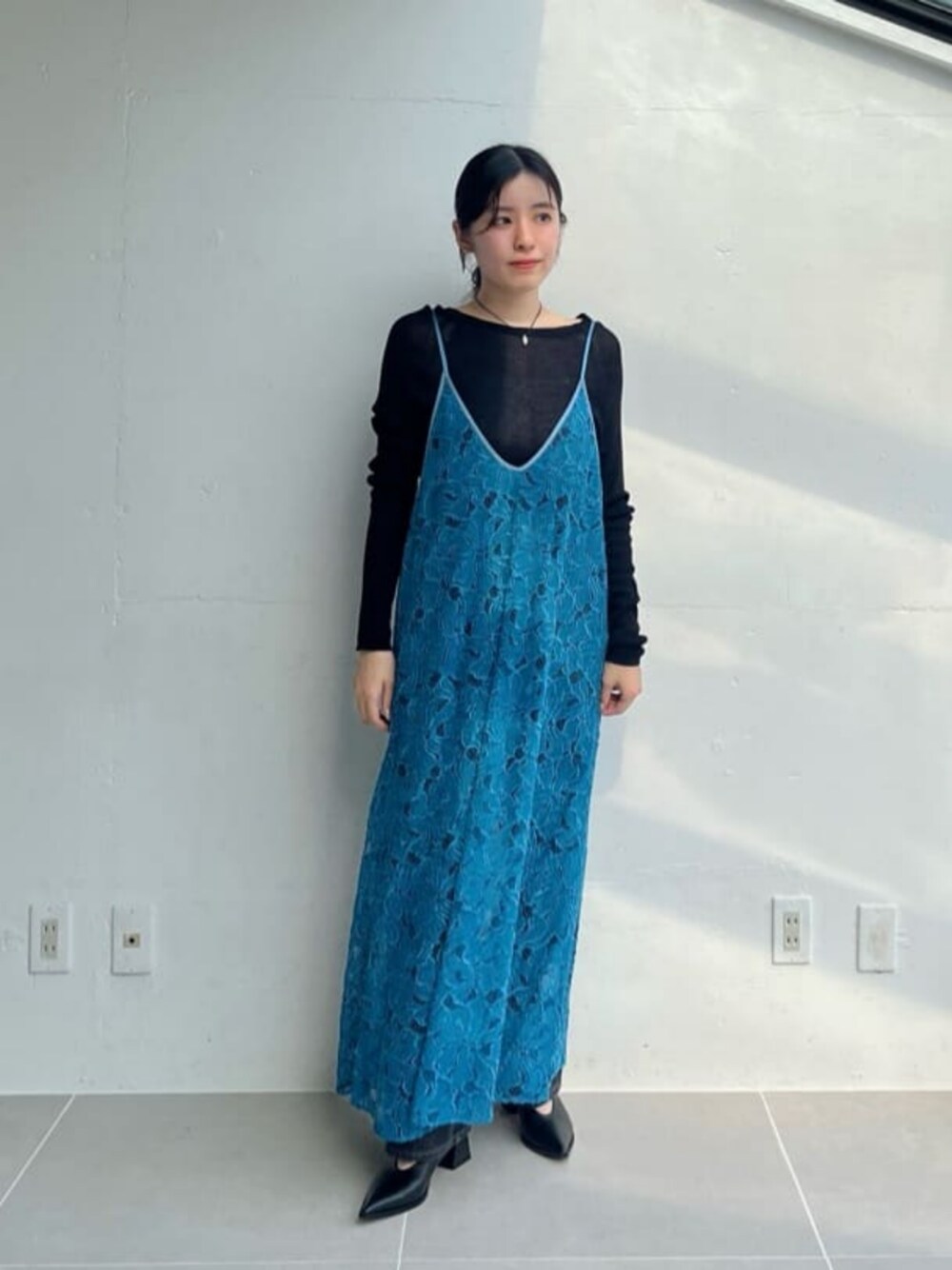 グレー系のデニムパンツ、ブラック系のパンプス、ブラック系のニット/セーターを着用したレディースの夏コーディネートの1枚目の写真