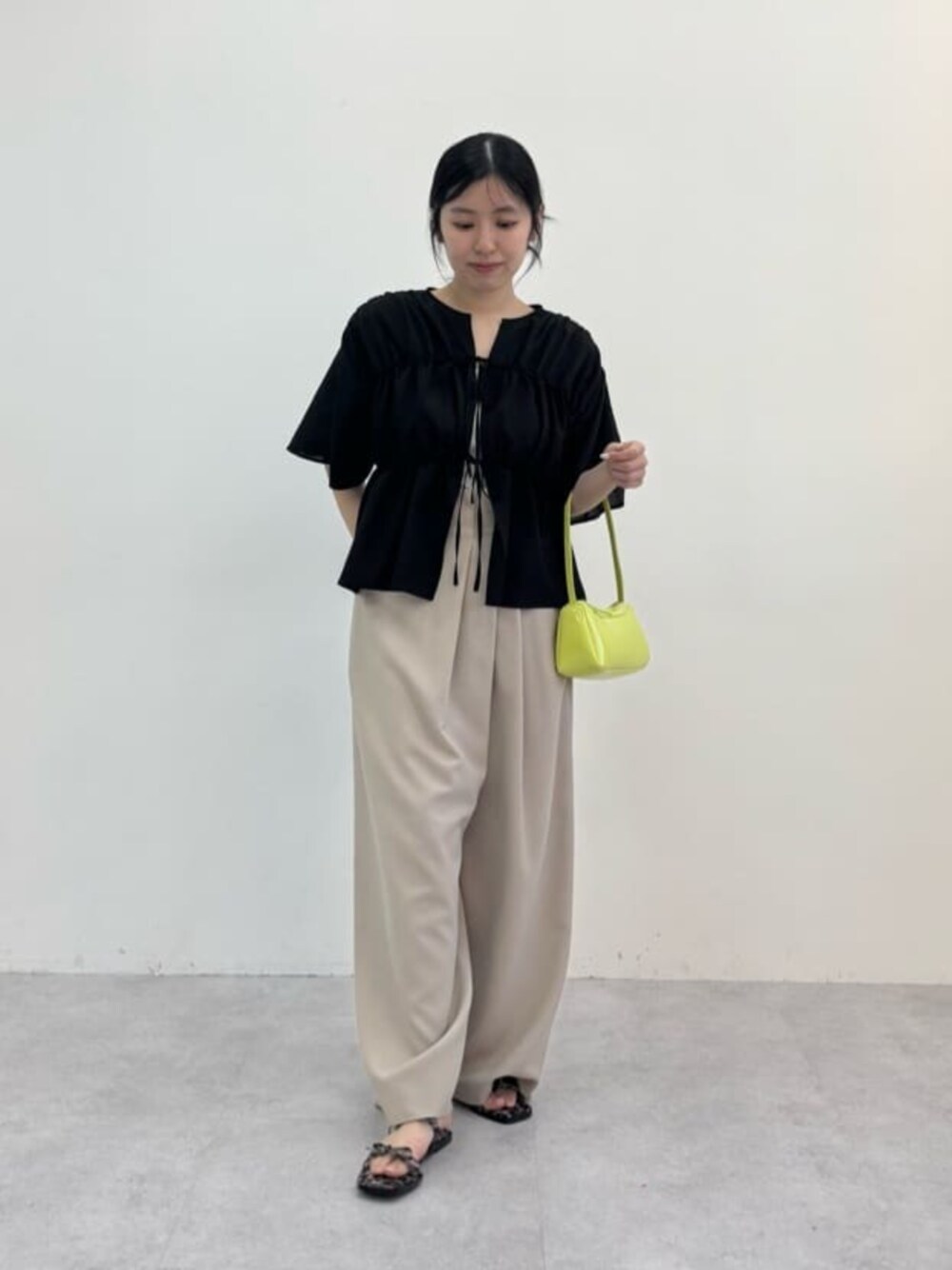 グリーン系のショルダーバッグ、ベージュ系のその他パンツ、ベージュ系のサンダルを着用したレディースの春コーディネートの1枚目の写真