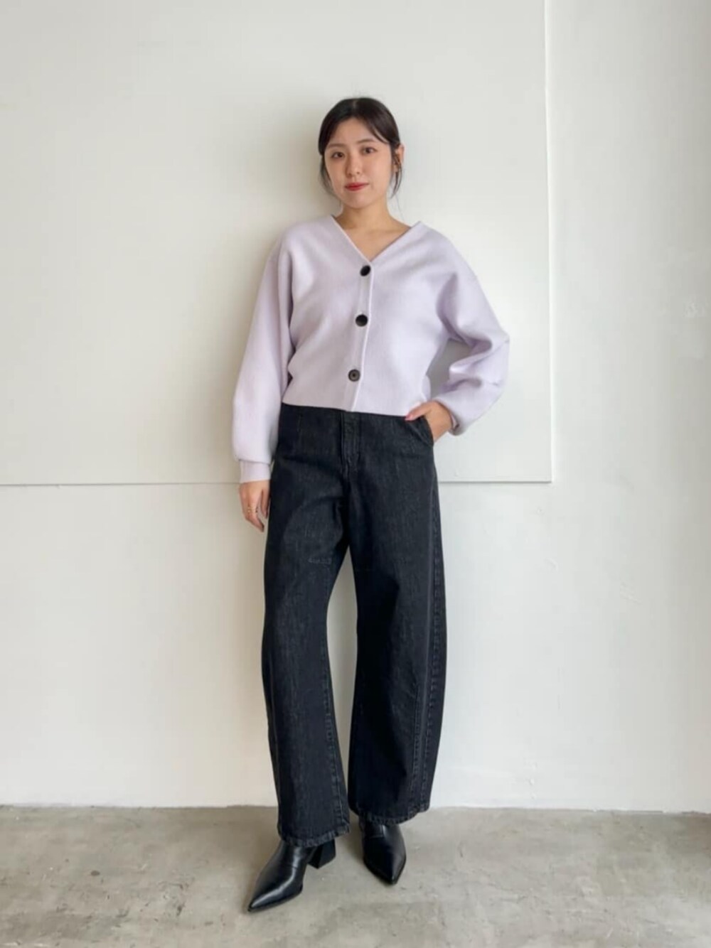 ブラック系のブーツ、パープル系のカーディガン/ボレロ、グレー系のデニムパンツを着用したレディースの冬コーディネートの1枚目の写真