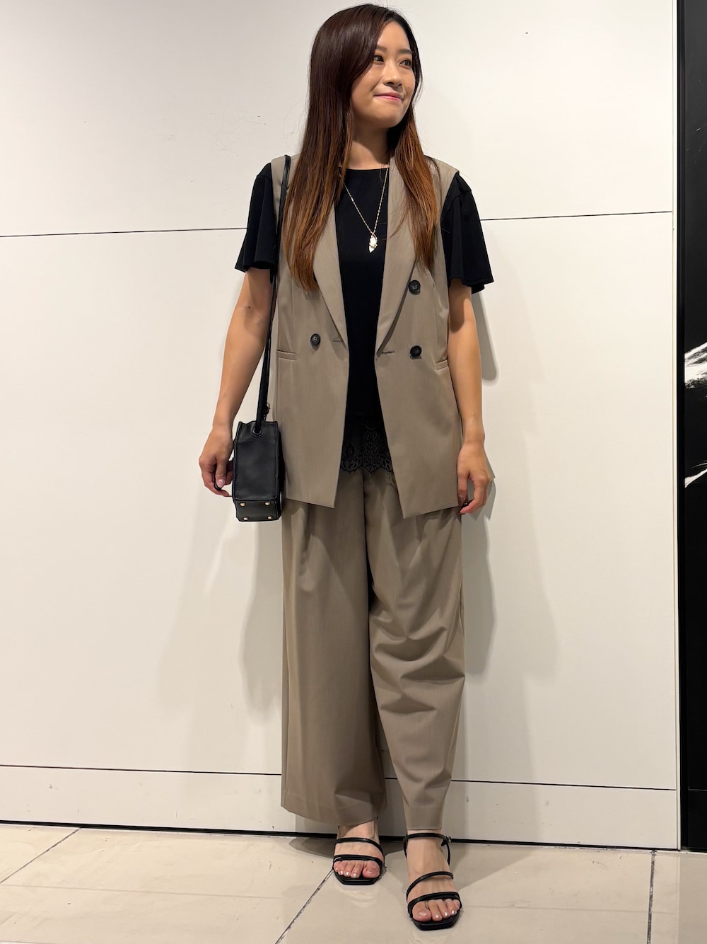 ブラック系のTシャツ/カットソー、ベージュ系のその他パンツ、ブラック系のショルダーバッグを着用したレディースの夏コーディネートの1枚目の写真