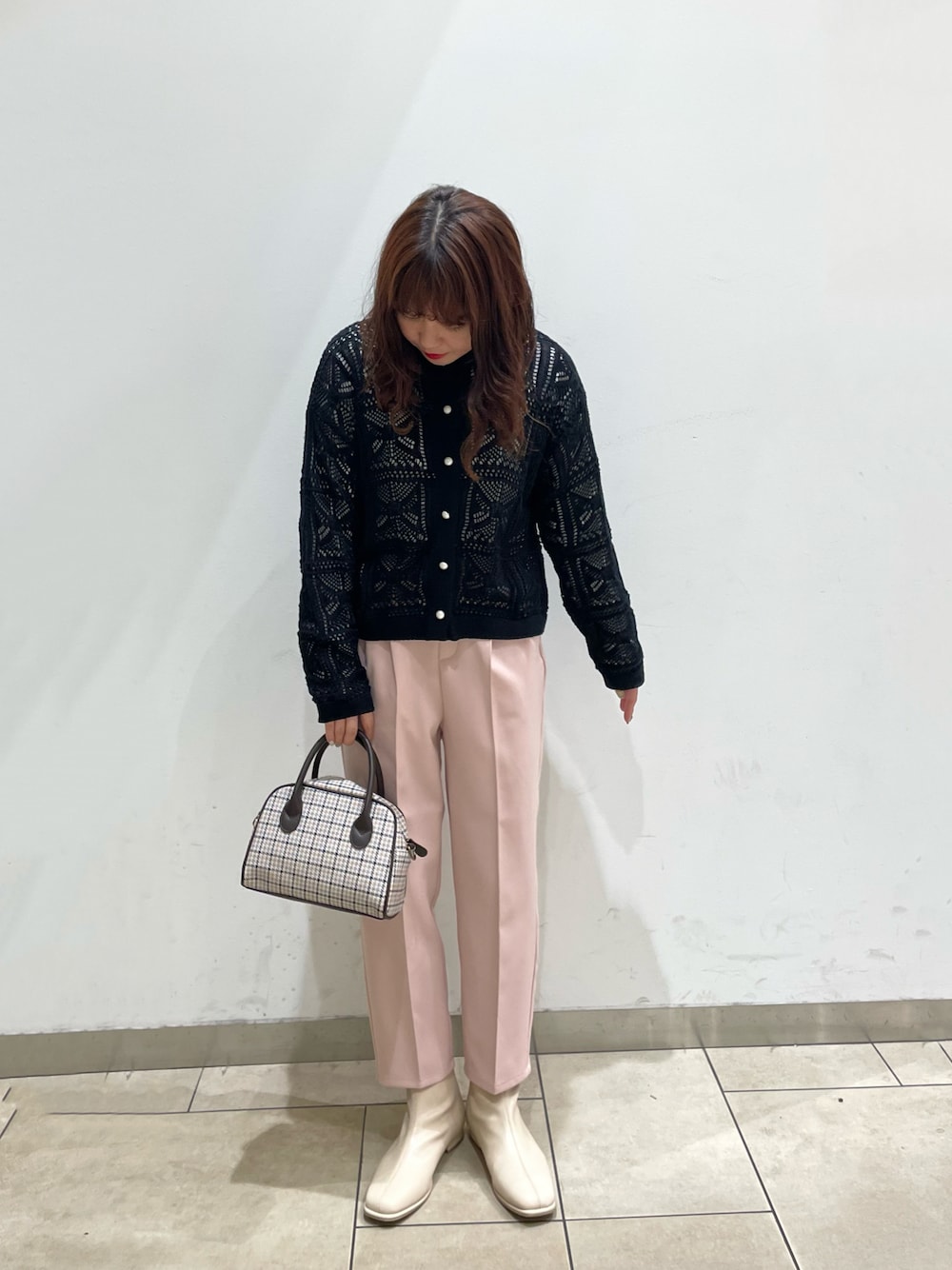 ブラック系のカーディガン/ボレロ、ホワイト系のTシャツ/カットソー、ブラウン系のショルダーバッグを着用したレディースの冬コーディネートの1枚目の写真