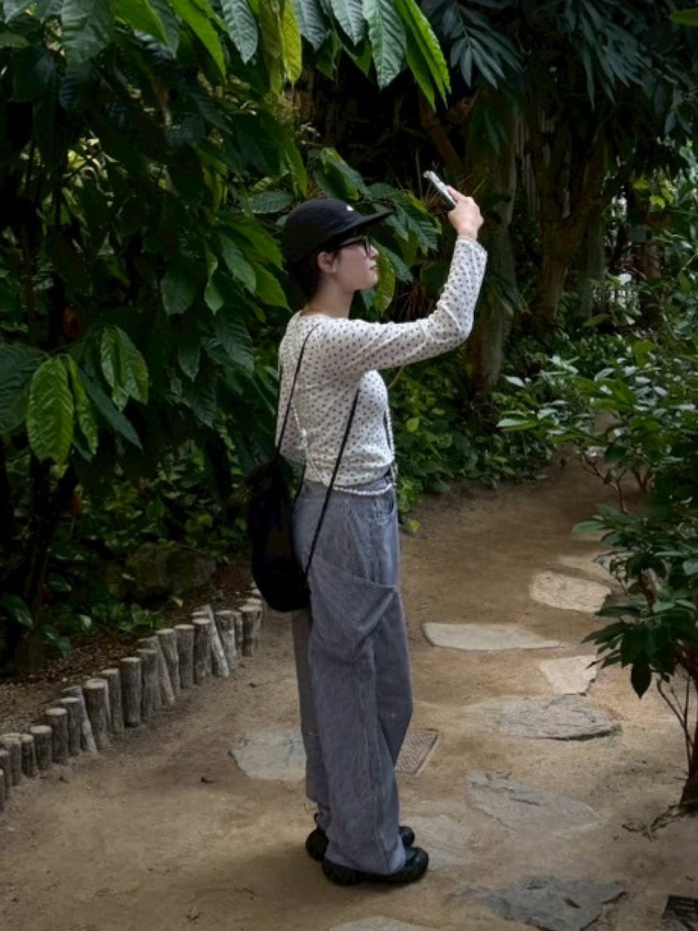 ブラック系のバックパック/リュック、レッド系のTシャツ/カットソー、ブルー系のデニムパンツを着用したレディースの秋コーディネートの1枚目の写真