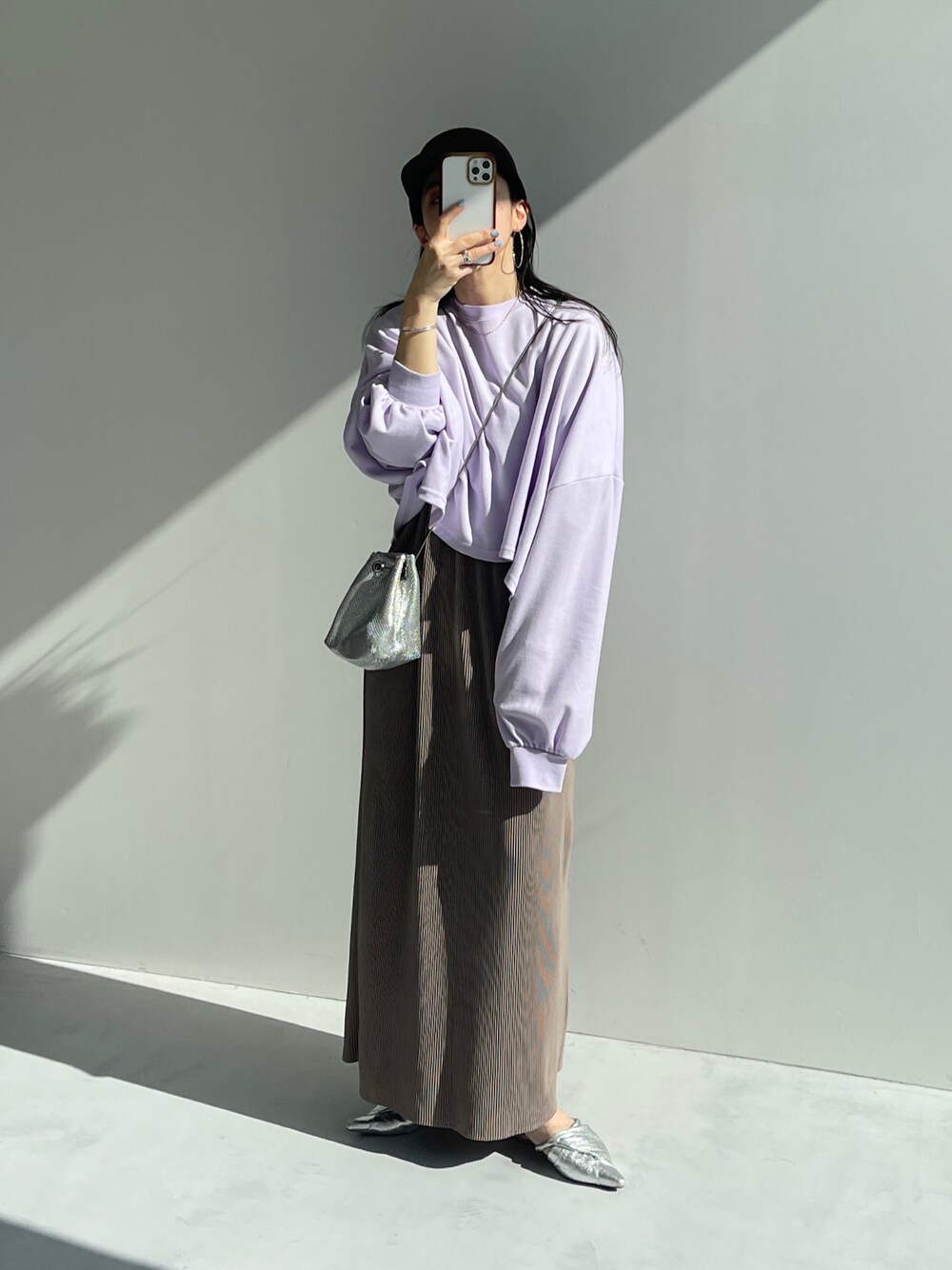 グレー系のワンピース、パープル系のTシャツ/カットソー、シルバー系のショルダーバッグを着用したレディースの春コーディネートの1枚目の写真