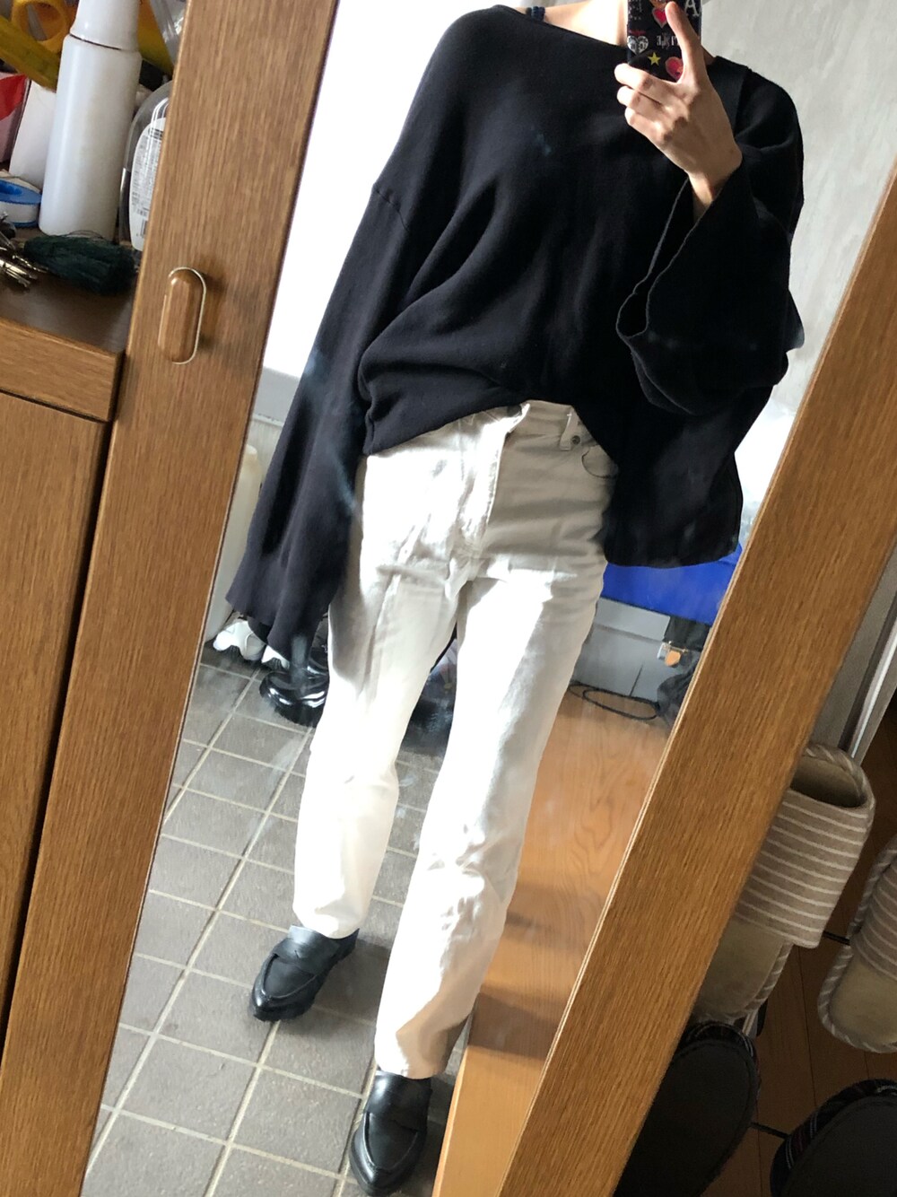 ブラック系のサンダル、ホワイト系のデニムパンツ、ブラック系のトートバッグを着用したレディースの秋コーディネートの1枚目の写真