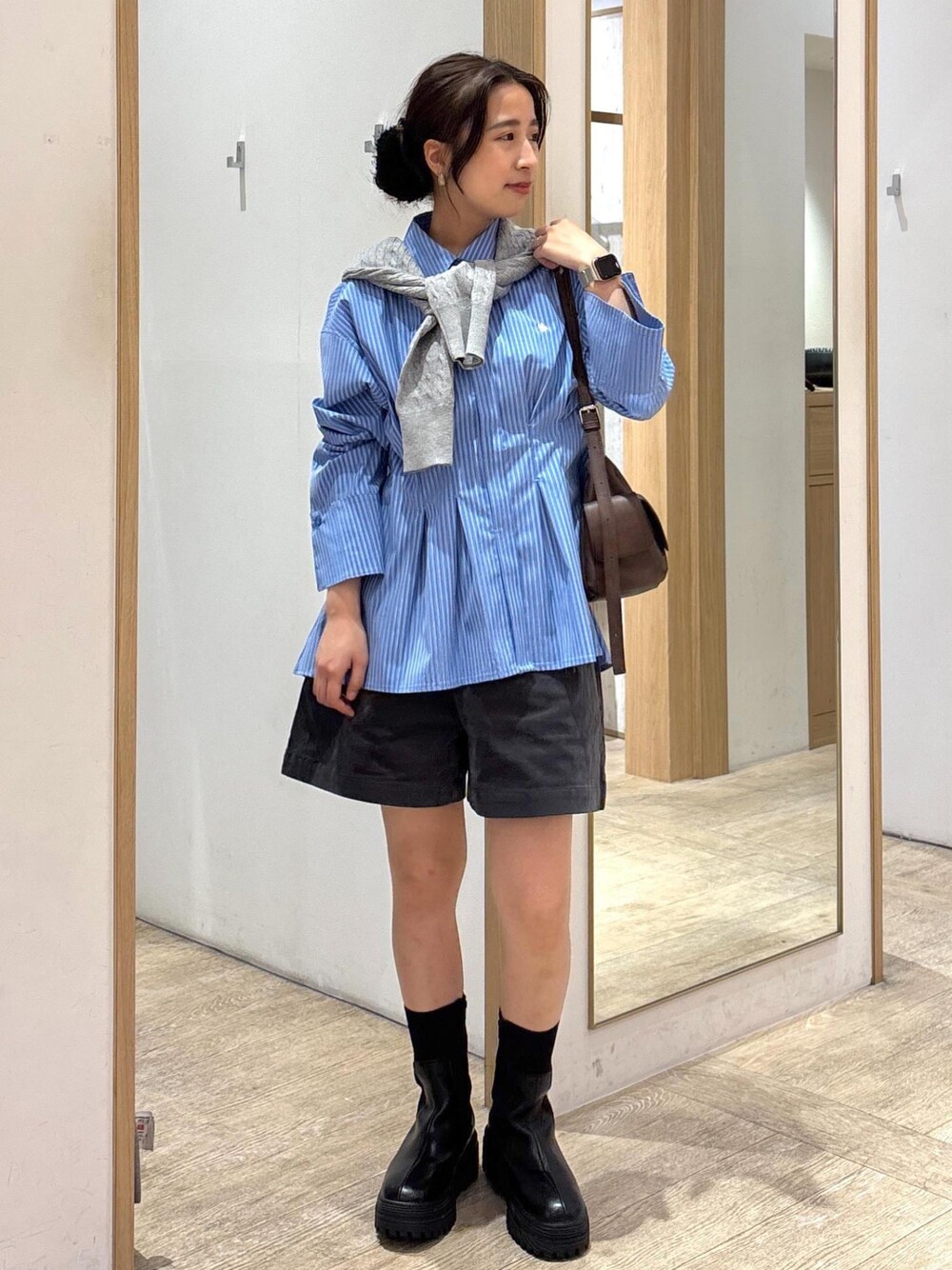 ブラック系のブーツ、ブルー系のシャツ/ブラウス、グレー系のカーディガン/ボレロを着用したレディースの秋コーディネートの1枚目の写真