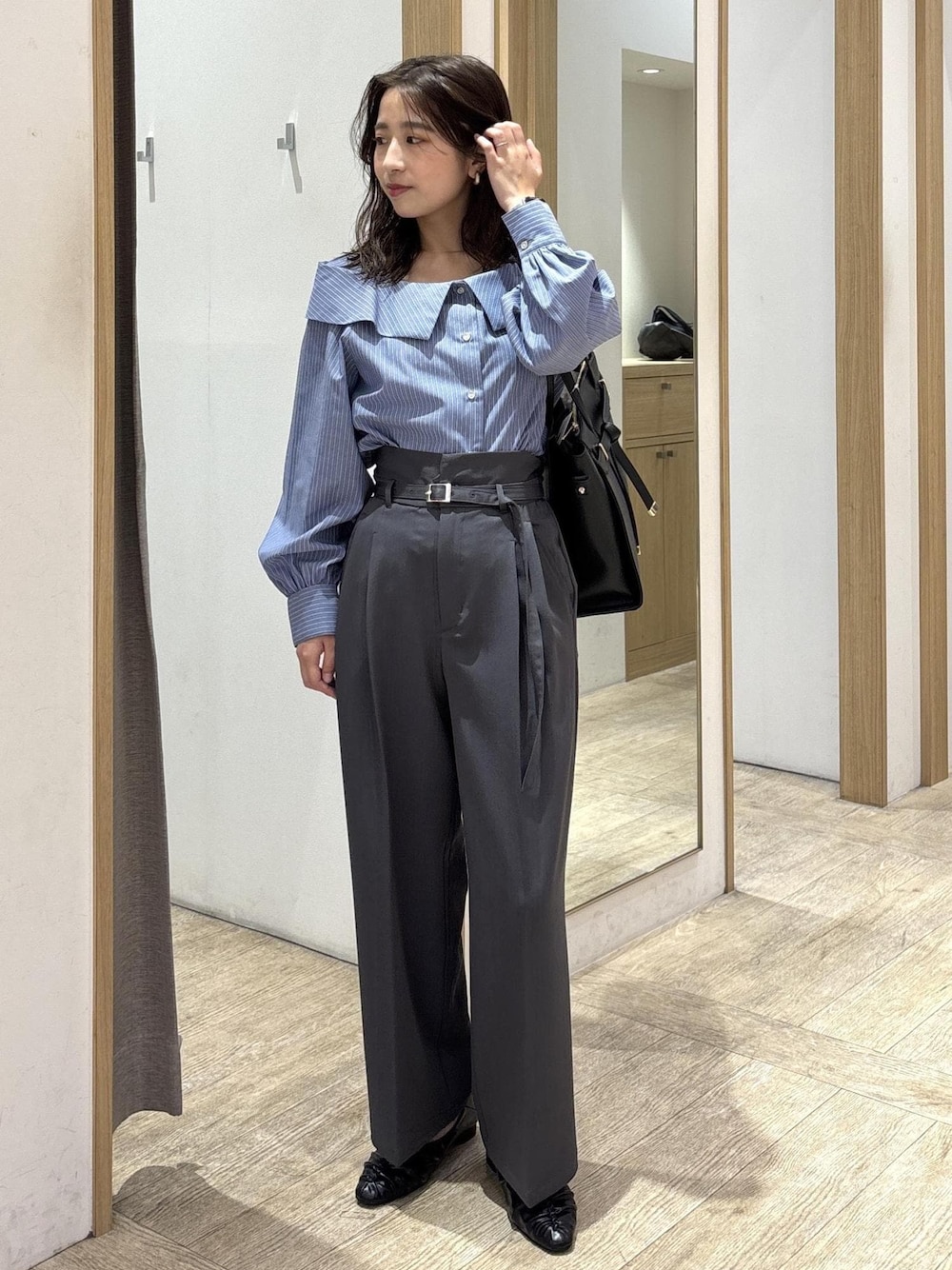 ブラック系のトートバッグ、ブラック系のパンプス、ブルー系のシャツ/ブラウスを着用したレディースの秋コーディネートの1枚目の写真