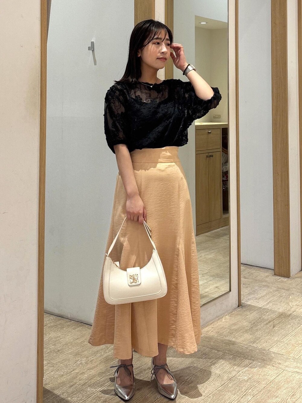 ホワイト系のハンドバッグ、シルバー系のパンプス、オレンジ系のスカートを着用したレディースの春コーディネートの1枚目の写真