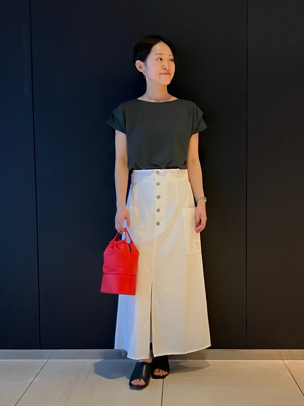 グリーン系のTシャツ/カットソー、ホワイト系のスカートを着用したレディースの春コーディネートの1枚目の写真