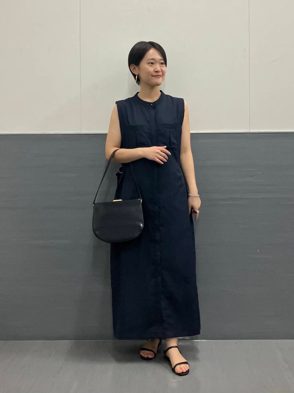 ブルー系のワンピース、ブラック系のハンドバッグを着用したレディースの夏コーディネートの1枚目の写真