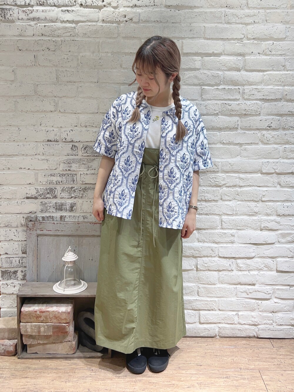 ホワイト系のシャツ/ブラウス、グリーン系のスカート、ホワイト系のTシャツ/カットソーを着用したレディースの春コーディネートの1枚目の写真