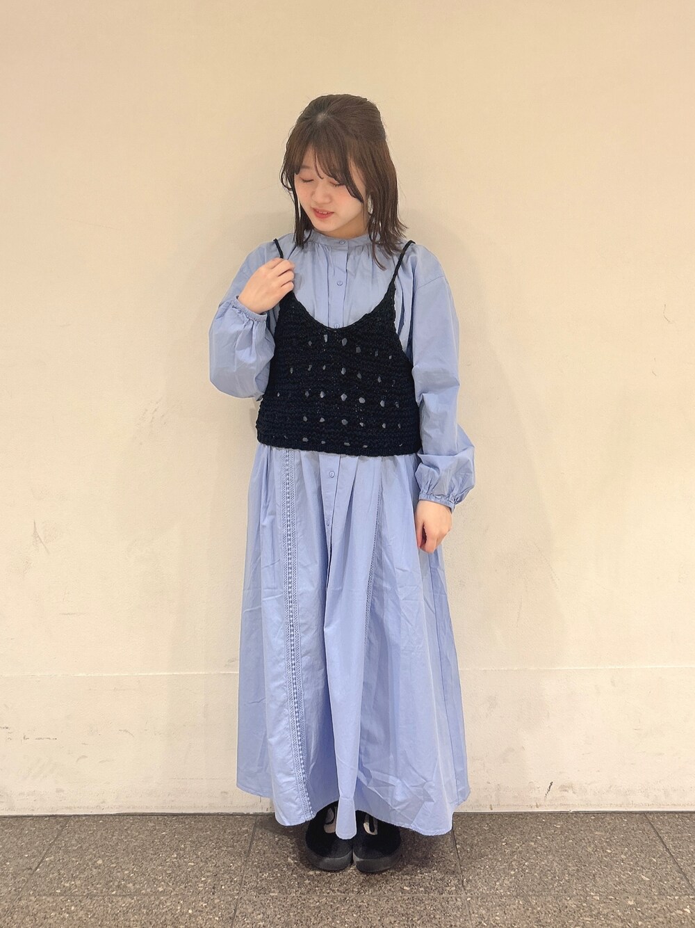 ブラック系のベスト、ブルー系のワンピースを着用したレディースの春コーディネートの1枚目の写真