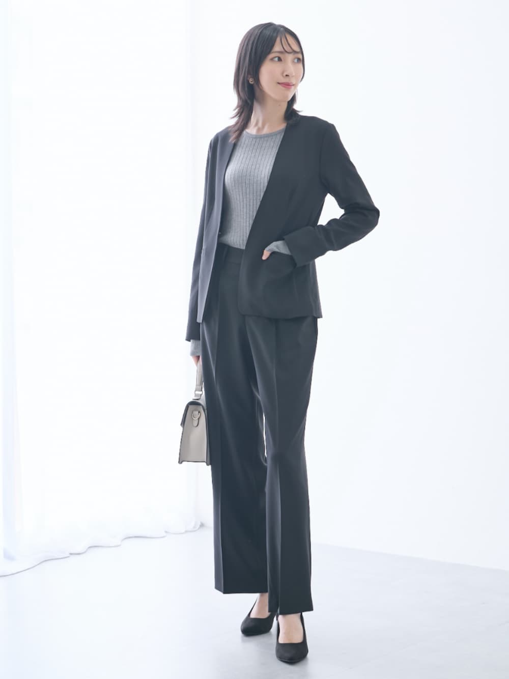 グレー系のニット/セーター、ブラック系のスーツセット、ブラック系のスーツセットを着用したレディースの秋コーディネートの1枚目の写真