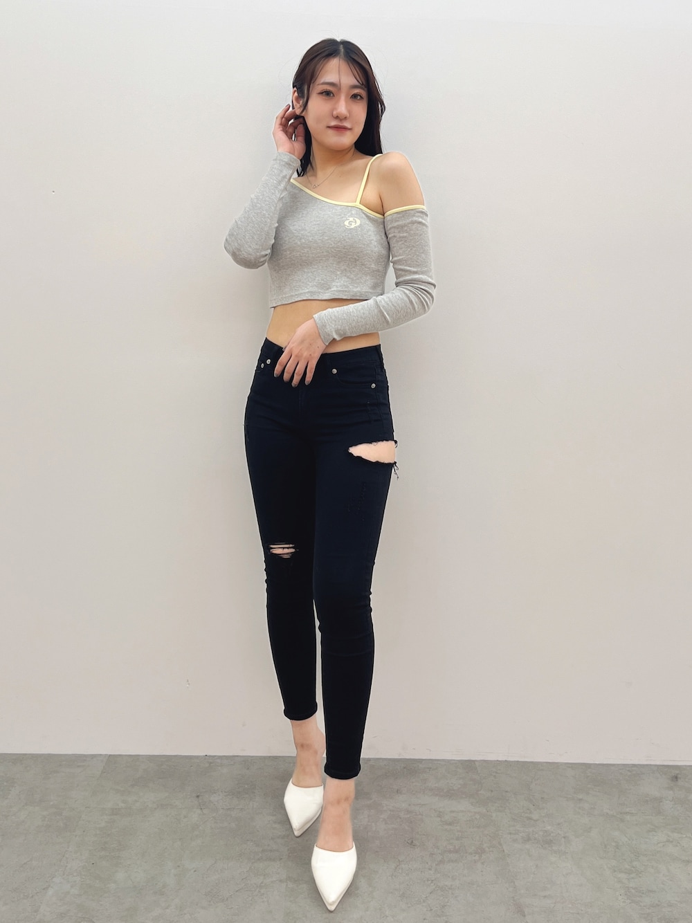 グレー系のTシャツ/カットソー、ブラック系のデニムパンツ、ホワイト系のパンプスを着用したレディースの春コーディネートの1枚目の写真