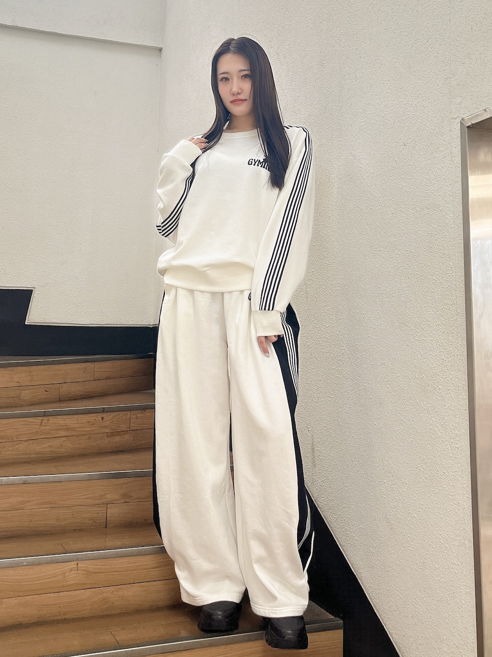 ホワイト系のスウェット、ホワイト系のスウェットパンツ、ブラック系のスニーカーを着用したレディースの冬コーディネートの1枚目の写真