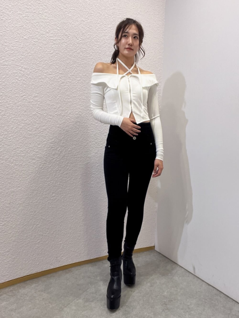 ブラック系のデニムパンツ、ブラック系のブーツ、ホワイト系のTシャツ/カットソーを着用したレディースの夏コーディネートの1枚目の写真