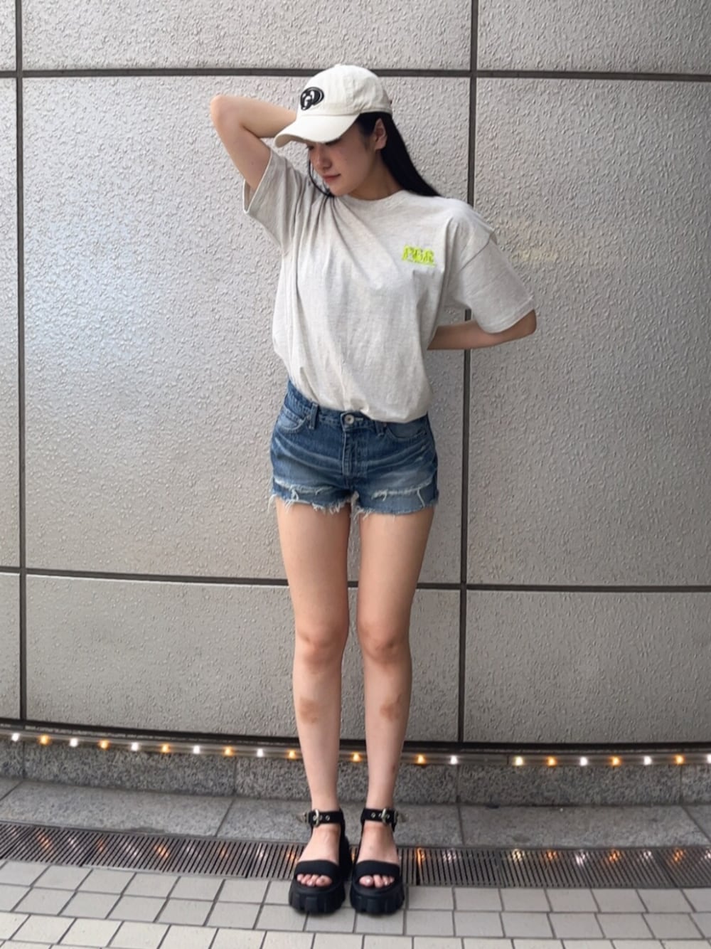 ブルー系のデニムパンツ、グレー系のTシャツ/カットソー、ブラック系のサンダルを着用したレディースの春コーディネートの1枚目の写真