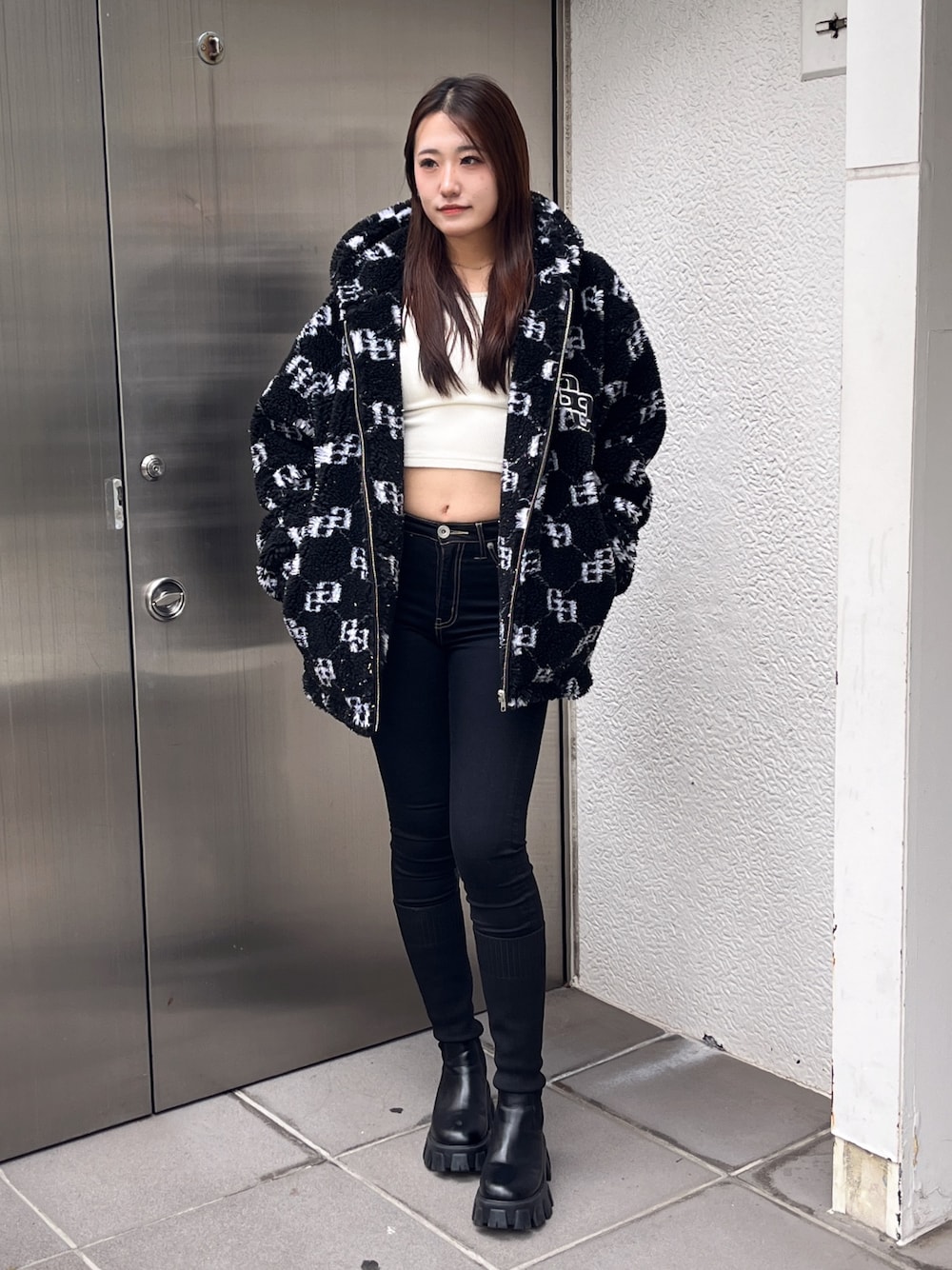 ブラック系のブルゾン、ホワイト系のTシャツ/カットソー、ブラック系のデニムパンツを着用したレディースの冬コーディネートの1枚目の写真