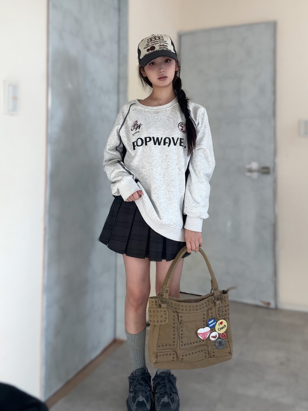 ホワイト系のスウェット、ブルー系のスカート、ベージュ系のショルダーバッグを着用したレディースの秋コーディネートの1枚目の写真