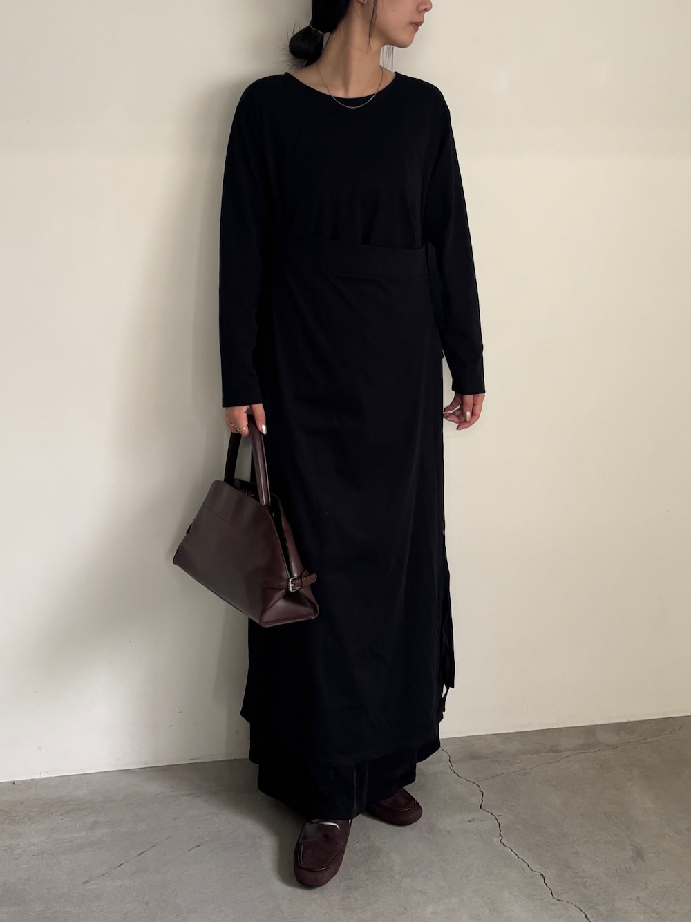 ブラック系のワンピース、ブラック系のスカート、ブラウン系のローファーを着用したレディースの秋コーディネートの1枚目の写真