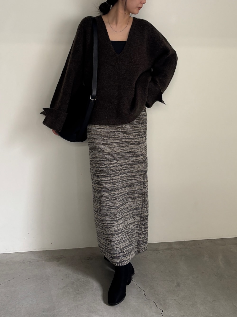 ブラック系のブーツ、グレー系のスカート、ブラウン系のニット/セーターを着用したレディースの秋コーディネートの1枚目の写真