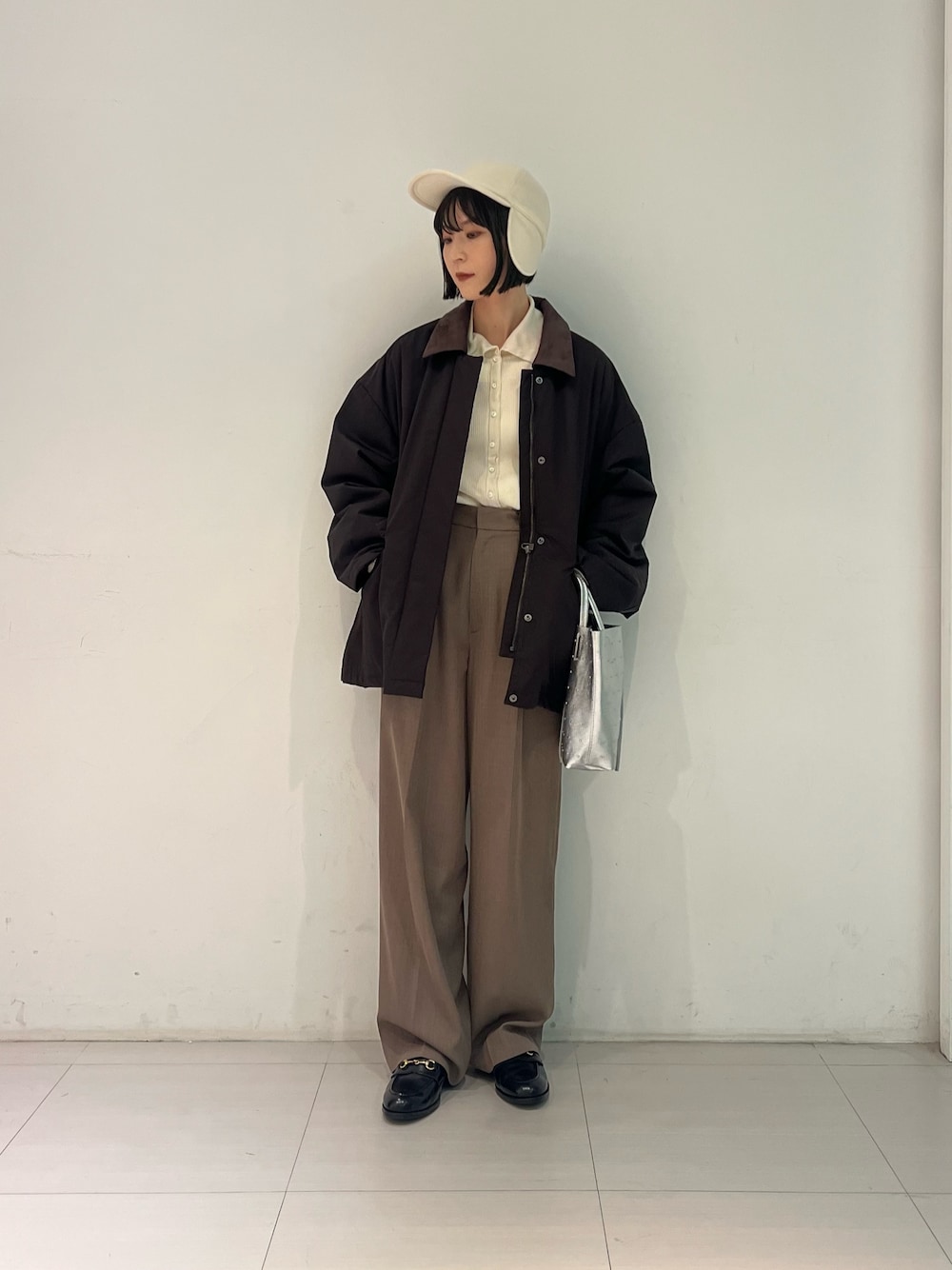 ブラック系のローファー、シルバー系のトートバッグ、ブラウン系のダウンジャケット/コートを着用したレディースの秋コーディネートの1枚目の写真