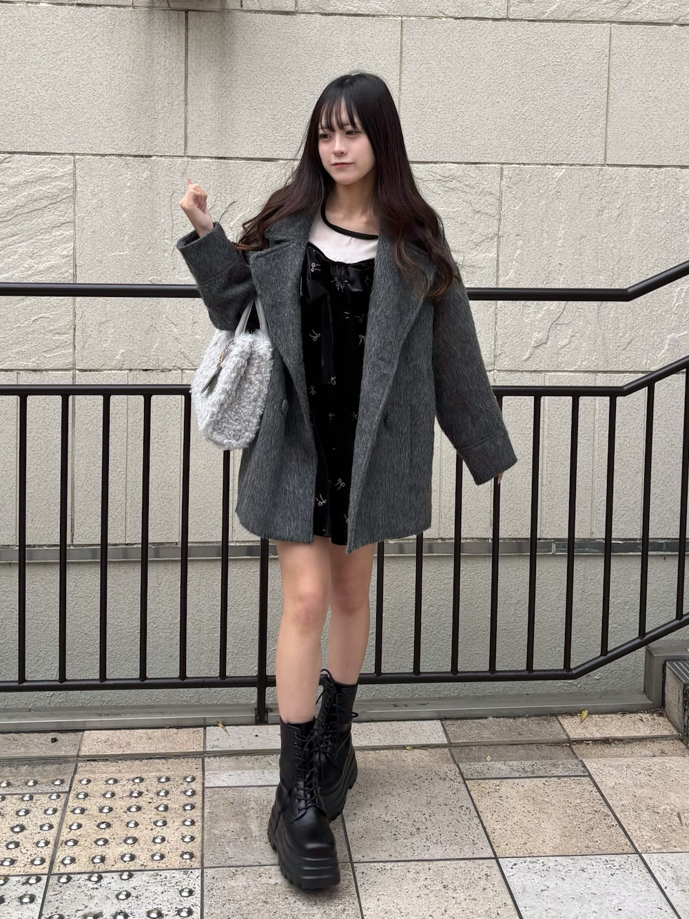 ブラック系のワンピース、グレー系のその他アウター、ブラック系のブーツを着用したレディースの秋コーディネートの1枚目の写真