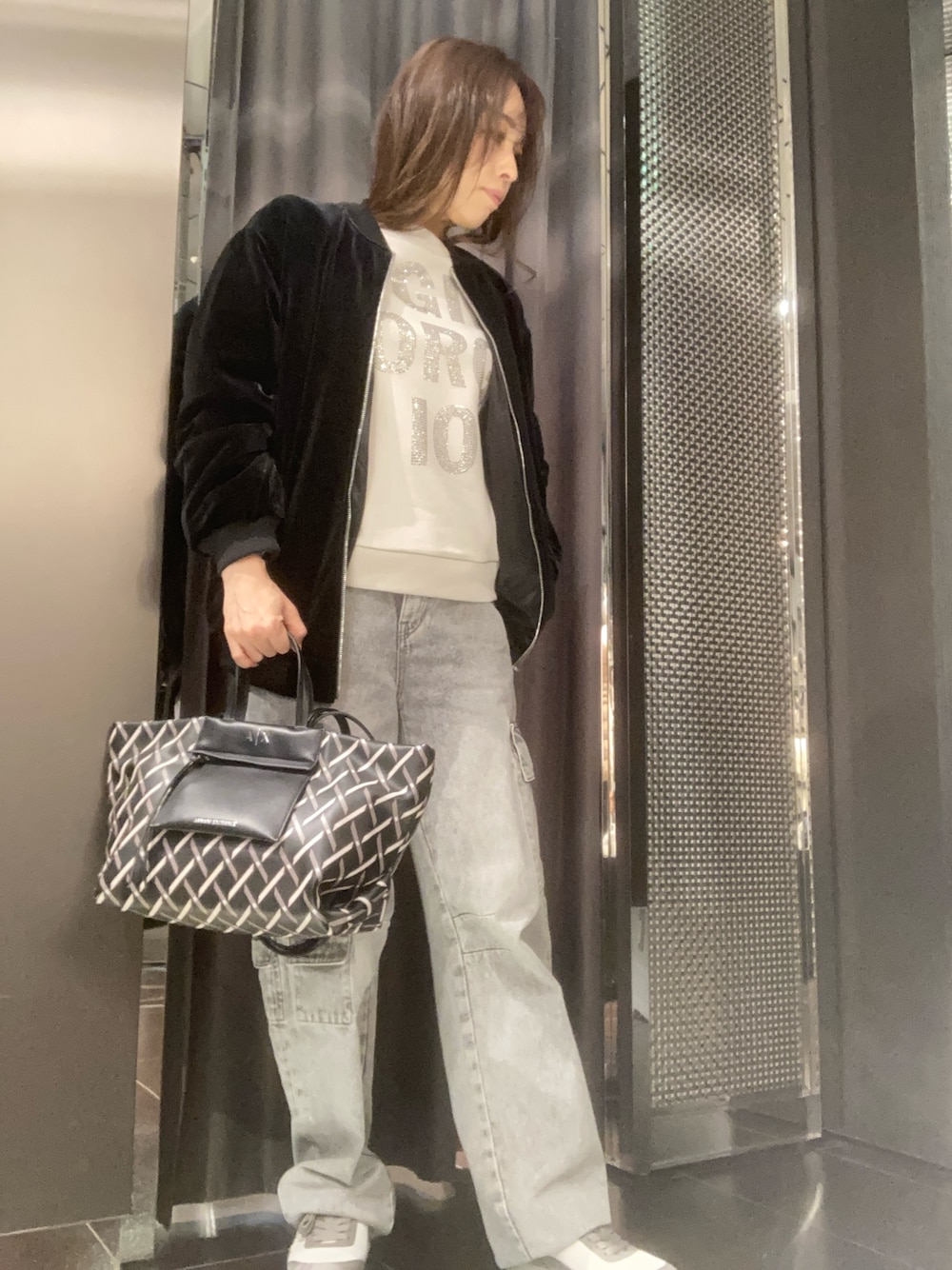 ブラック系のブルゾン、ホワイト系のスウェット、グレー系のカーゴパンツを着用したレディースの秋コーディネートの1枚目の写真