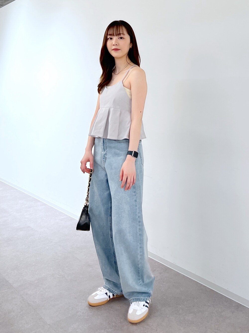 ブルー系のデニムパンツ、ブラック系のトートバッグ、グレー系のベストを着用したレディースの夏コーディネートの1枚目の写真