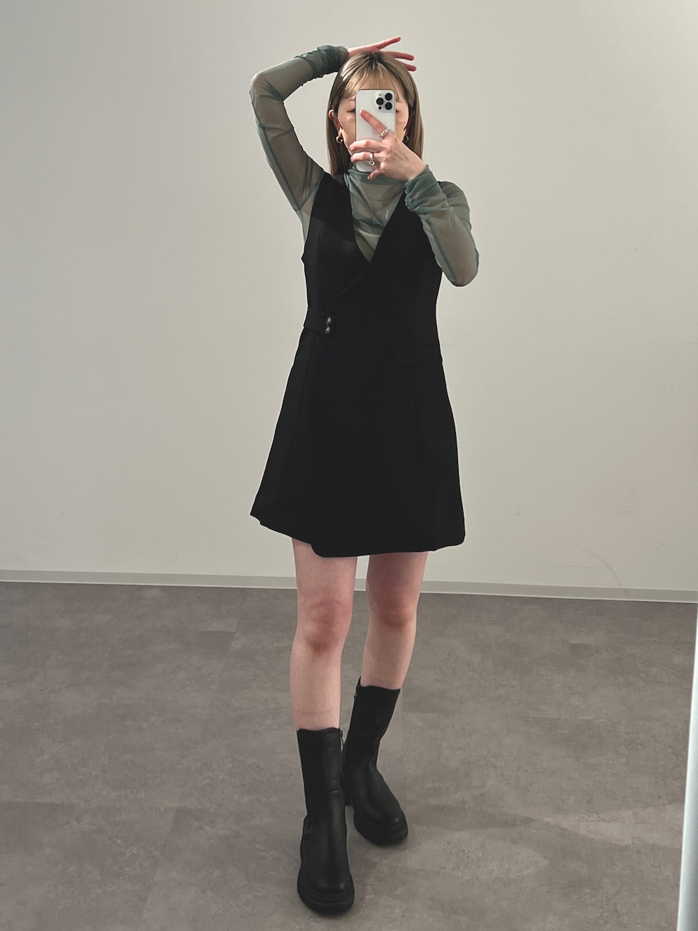 ブラック系のジャンパースカート、グリーン系のTシャツ/カットソーを着用したレディースの冬コーディネートの1枚目の写真