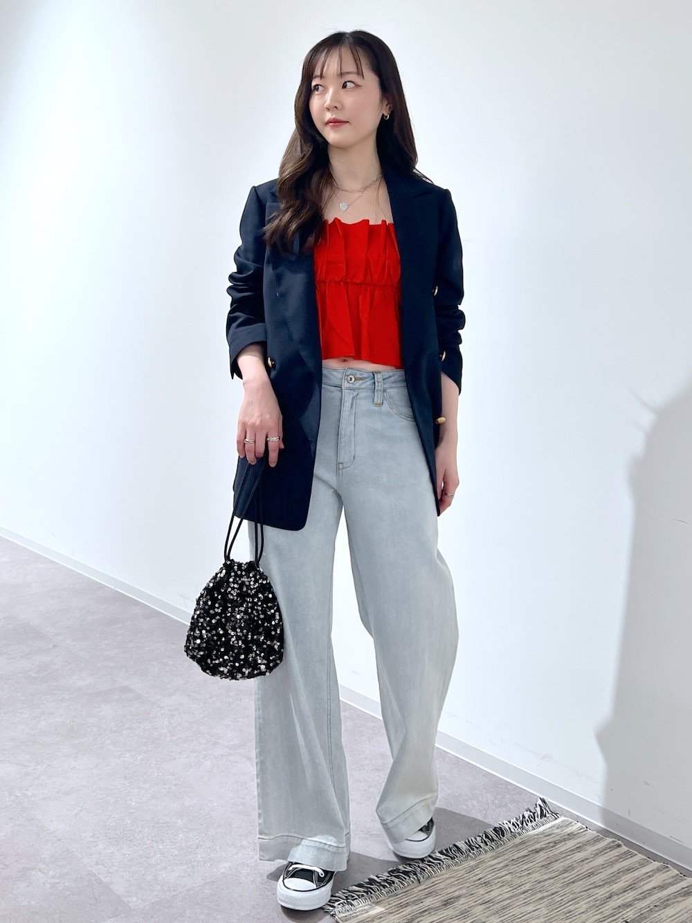 ブルー系のテーラードジャケット、ブルー系のデニムパンツ、ブラック系のハンドバッグを着用したレディースの春コーディネートの1枚目の写真