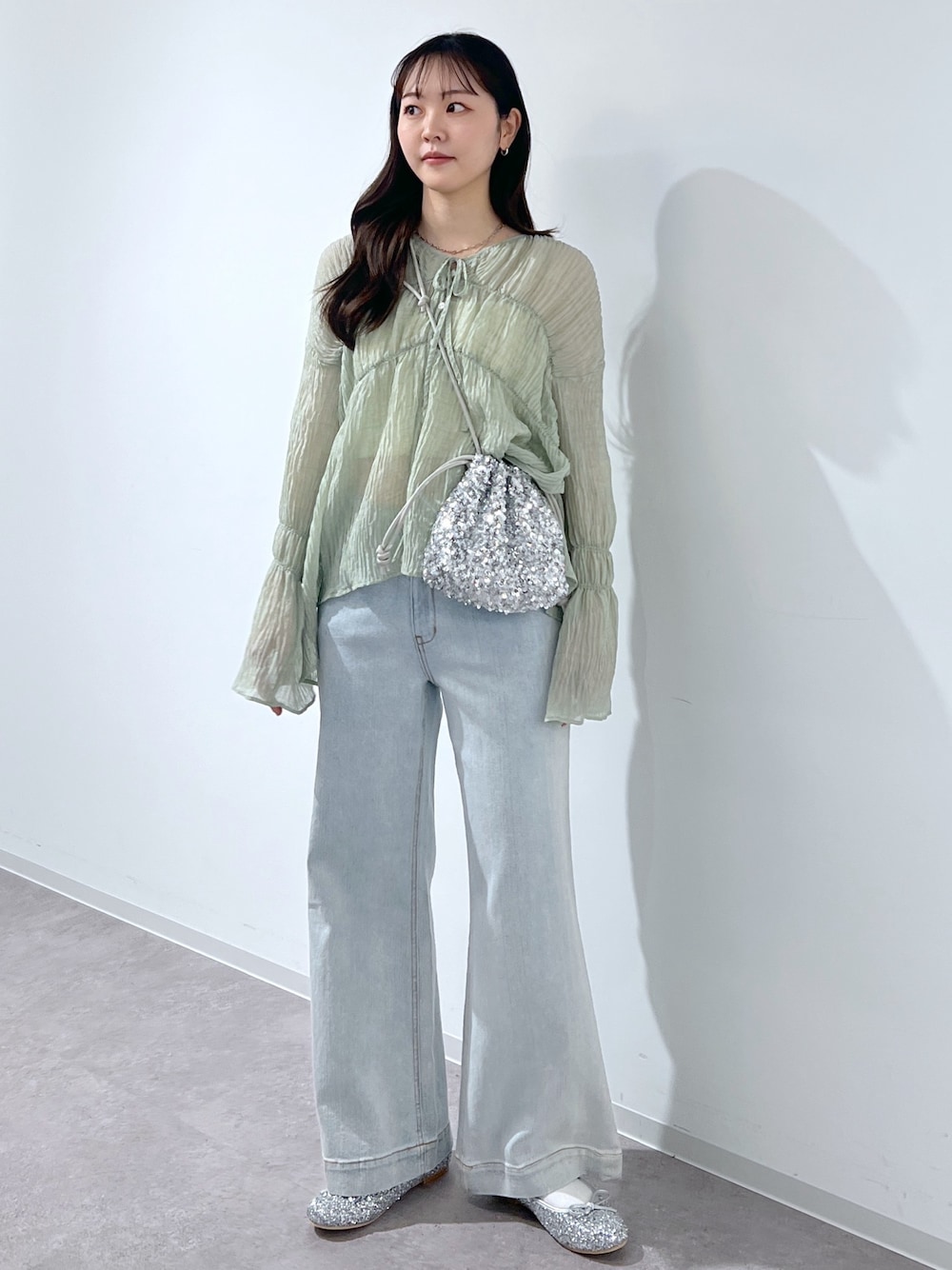 グリーン系のシャツ/ブラウス、シルバー系のバレエシューズ、シルバー系のハンドバッグを着用したレディースの春コーディネートの1枚目の写真