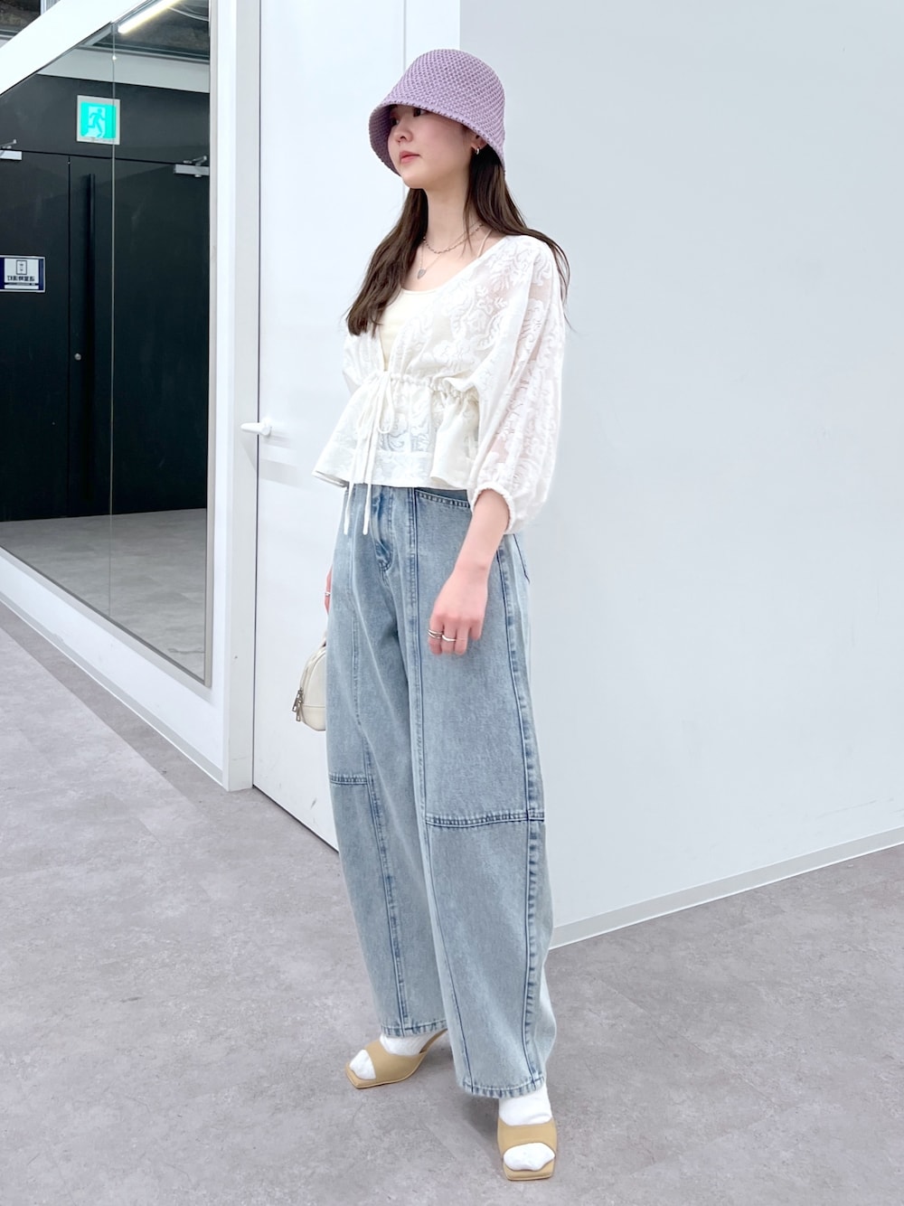 ブルー系のデニムパンツ、ホワイト系のカーディガン/ボレロ、ベージュ系のサンダルを着用したレディースの春コーディネートの1枚目の写真