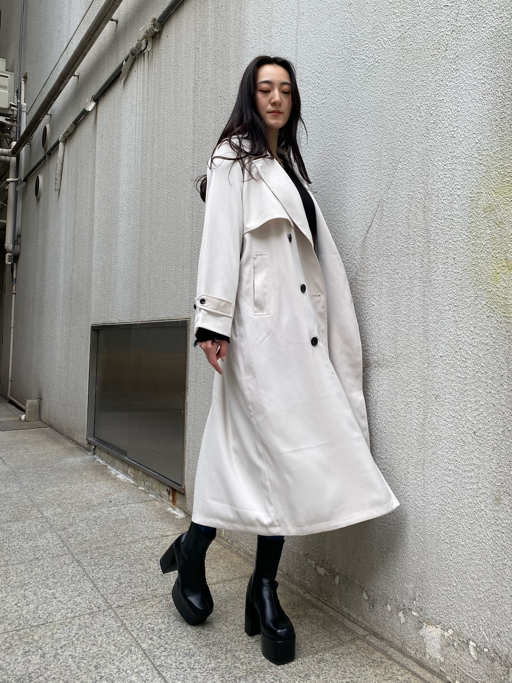 ブラック系のニット/セーター、ブルー系のデニムパンツ、ブラック系のブーツを着用したレディースの冬コーディネートの1枚目の写真