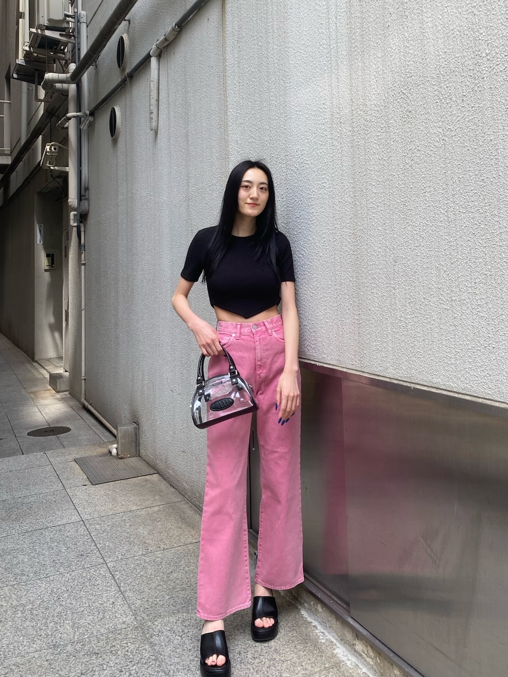 ピンク系のデニムパンツ、ブラック系のTシャツ/カットソー、その他のハンドバッグを着用したレディースの春コーディネートの1枚目の写真