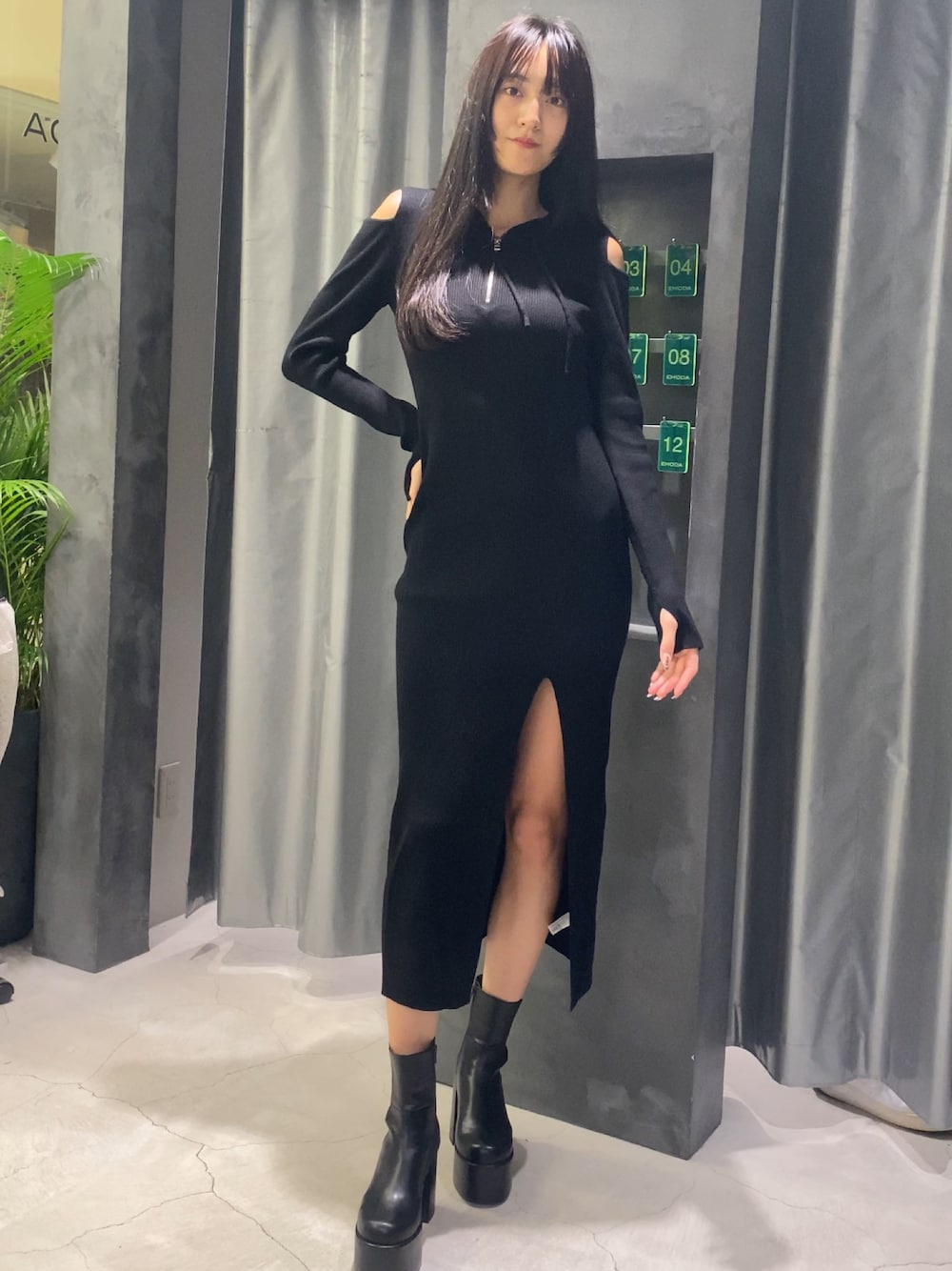 ブラック系のワンピース、ブラック系のブーツを着用したレディースの秋コーディネートの1枚目の写真