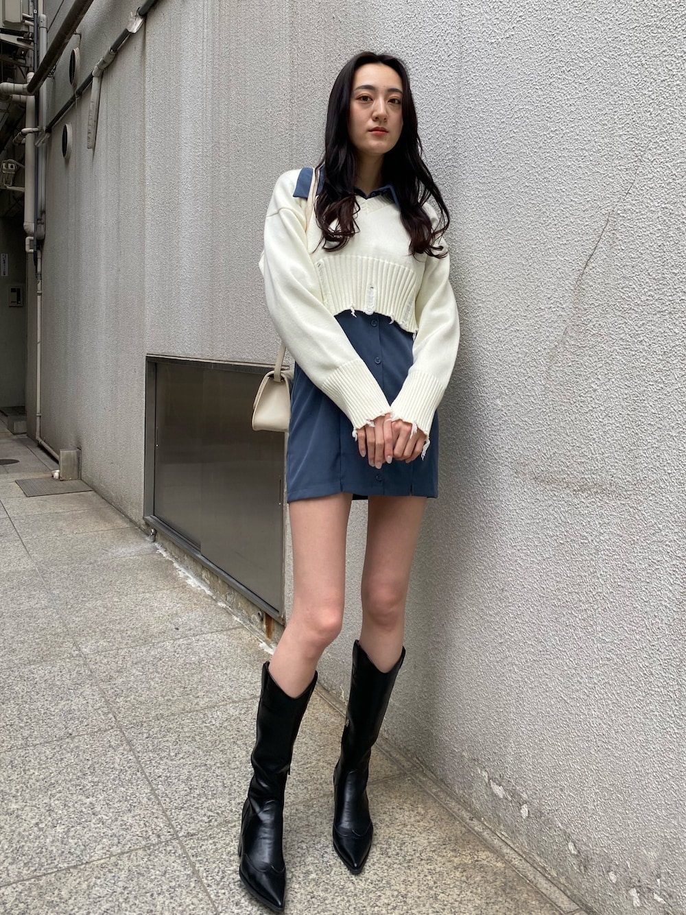 ホワイト系のニット/セーター、ブルー系のワンピース、ホワイト系のショルダーバッグを着用したレディースの冬コーディネートの1枚目の写真