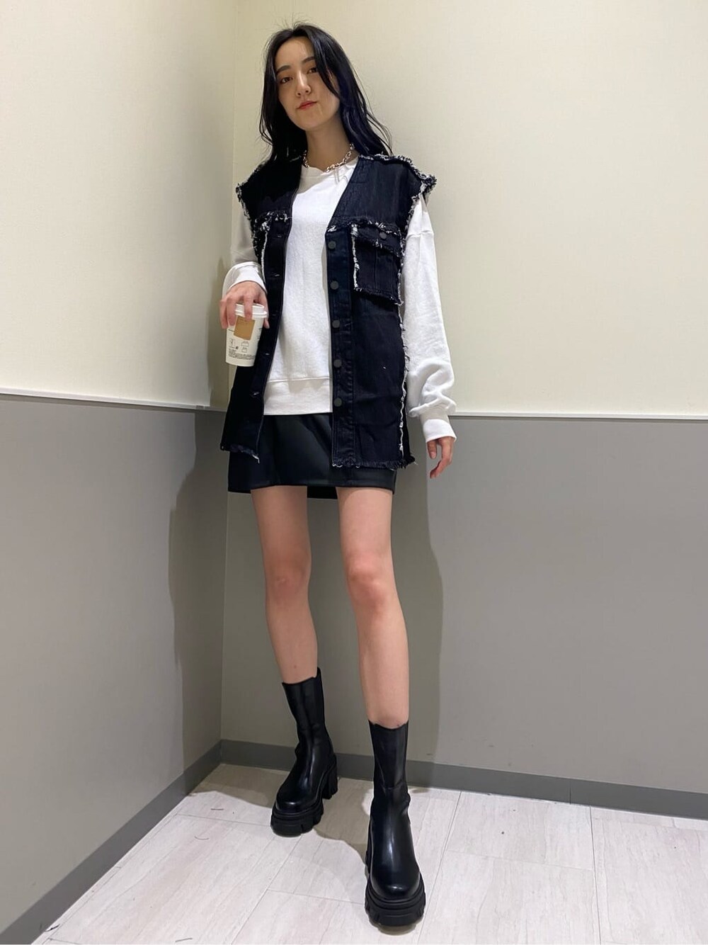 ブラック系のブーツ、ブラック系のデニムジャケット、ホワイト系のスウェットを着用したレディースの秋コーディネートの1枚目の写真