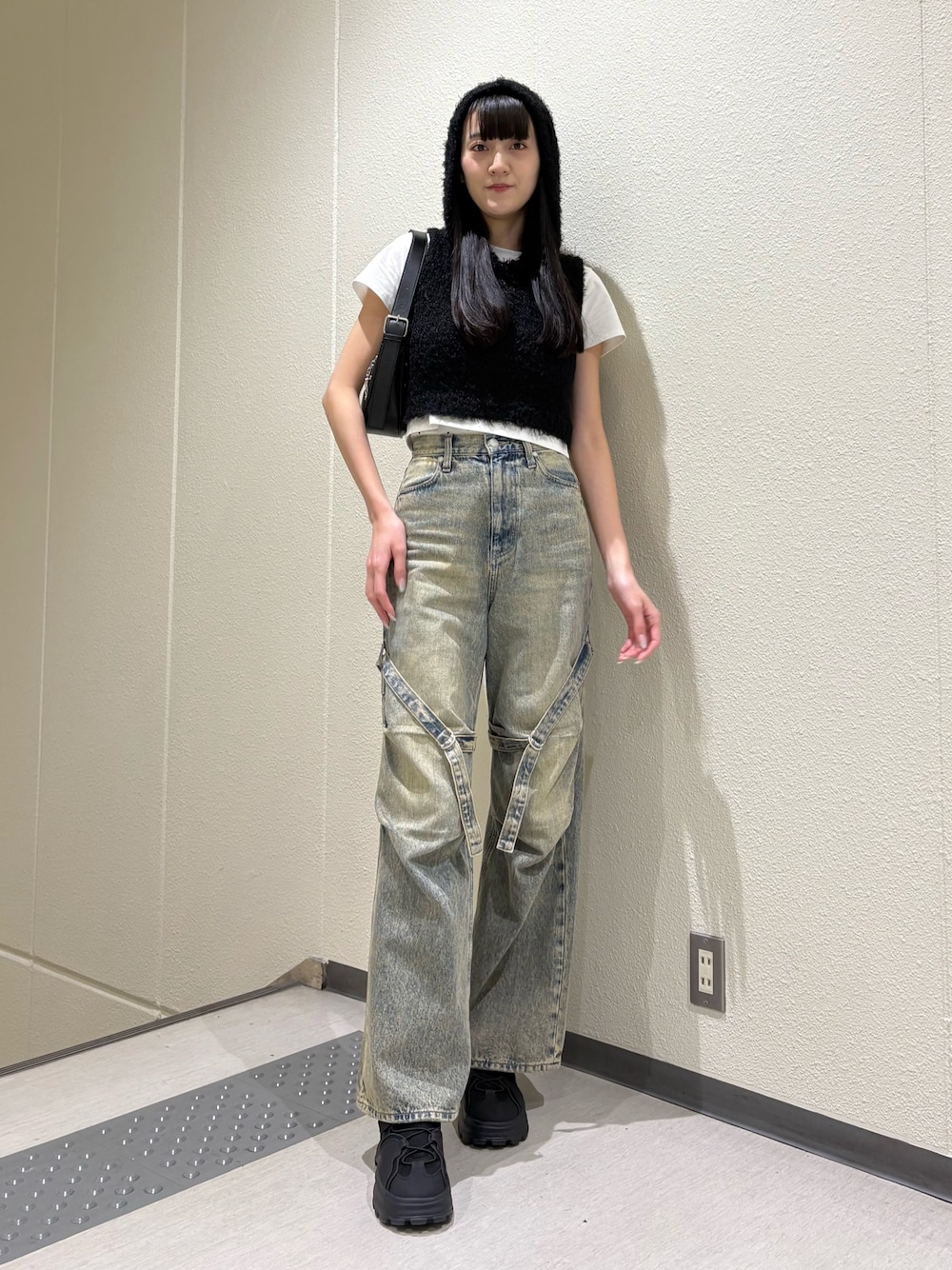 ブルー系のデニムパンツ、ブラック系のハンドバッグ、ホワイト系のTシャツ/カットソーを着用したレディースの春コーディネートの1枚目の写真