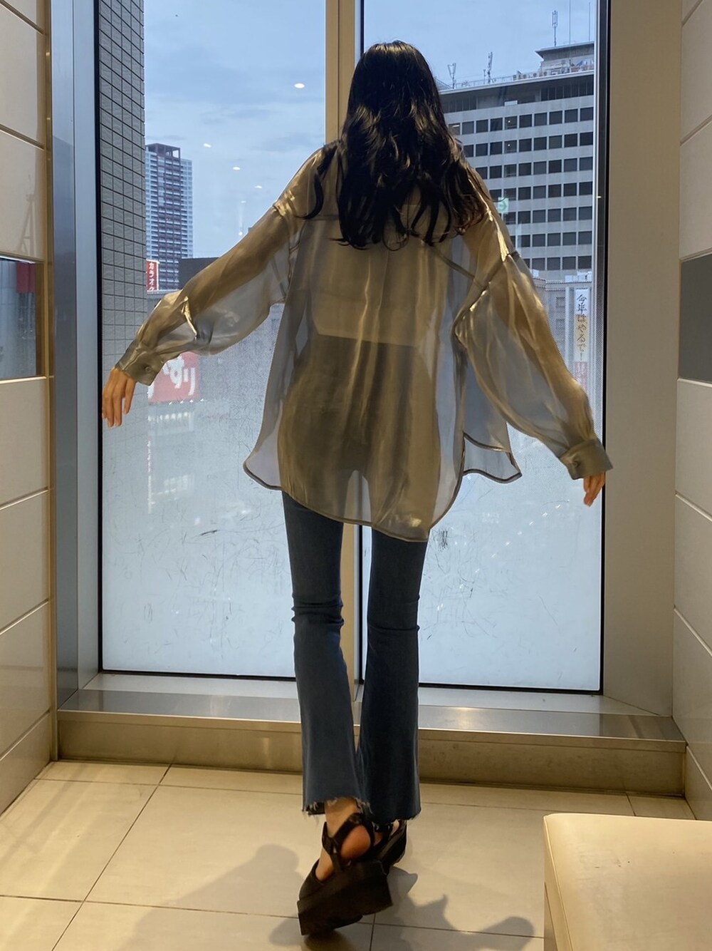 ブラック系のサンダル、グレー系のシャツ/ブラウス、ブルー系のデニムパンツを着用したレディースの夏コーディネートの1枚目の写真