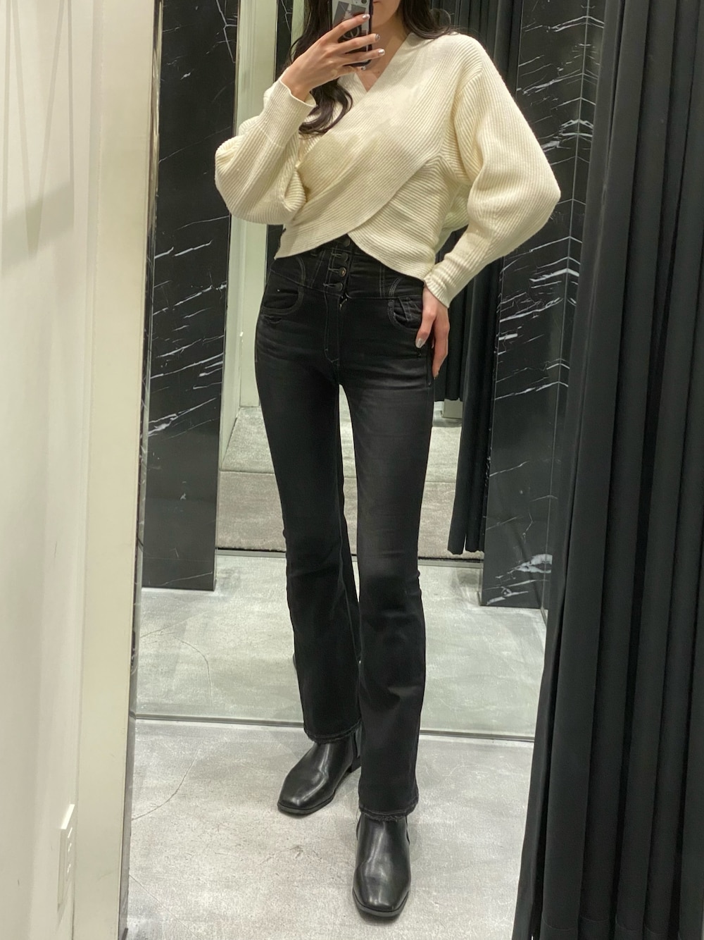 ホワイト系のニット/セーター、ブラック系のデニムパンツを着用したレディースの冬コーディネートの1枚目の写真