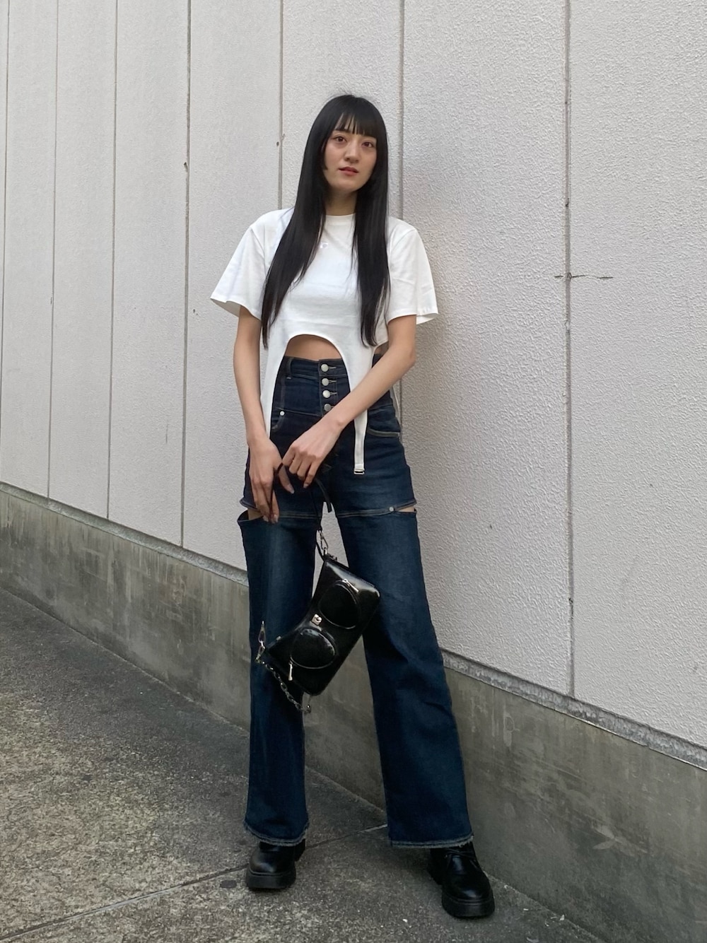 ブルー系のデニムパンツ、ブラック系のショルダーバッグ、ホワイト系のTシャツ/カットソーを着用したレディースの春コーディネートの1枚目の写真