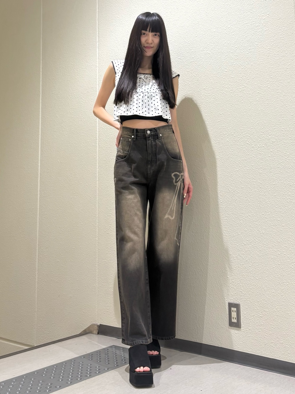 ブラック系のデニムパンツ、ホワイト系のタンクトップ、ブラック系のTシャツ/カットソーを着用したレディースの夏コーディネートの1枚目の写真