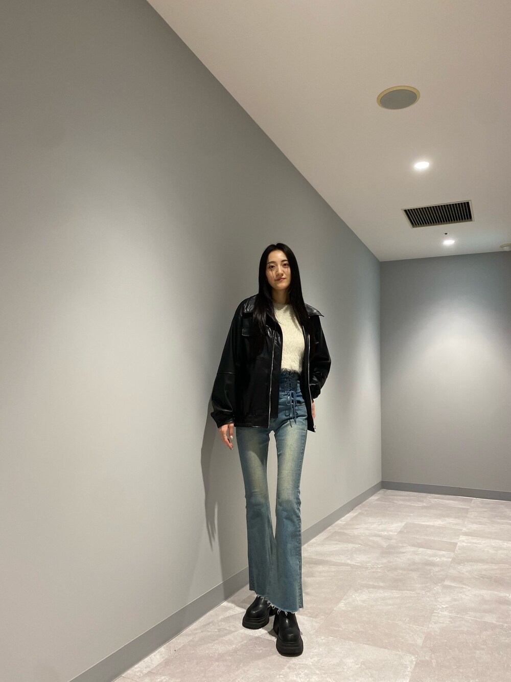 ブラック系のブルゾン、ブルー系のデニムパンツ、ホワイト系のニット/セーターを着用したレディースの冬コーディネートの1枚目の写真