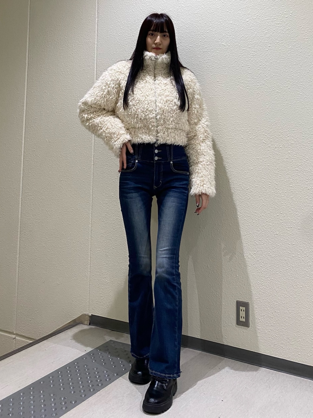 ブルー系のデニムパンツ、ホワイト系のブルゾンを着用したレディースの秋コーディネートの1枚目の写真