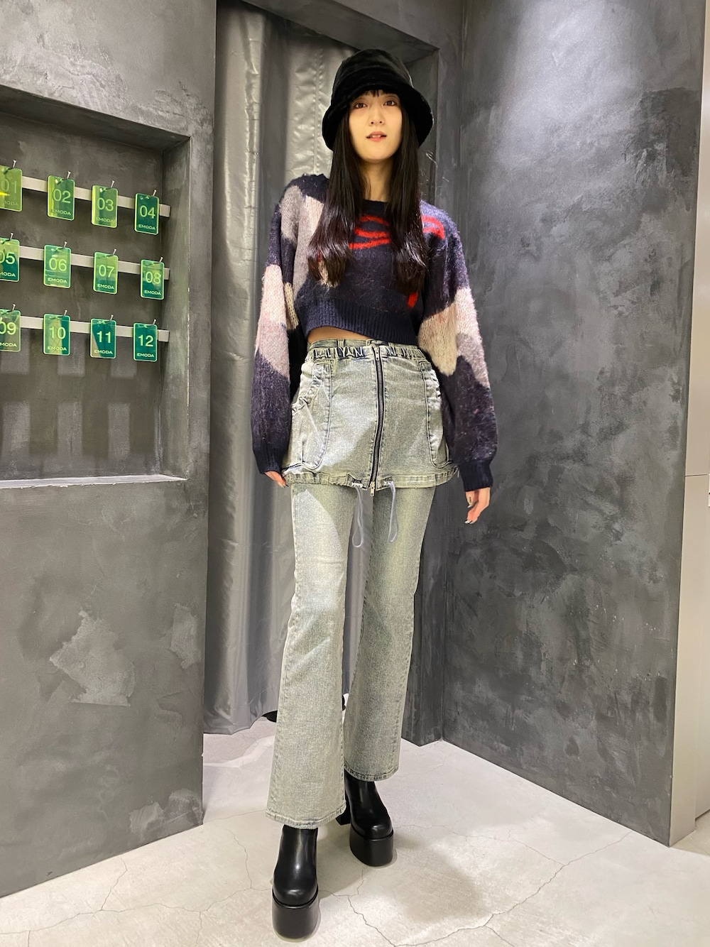 ブルー系のデニムパンツ、ブルー系のニット/セーター、ブラック系のブーツを着用したレディースの秋コーディネートの1枚目の写真