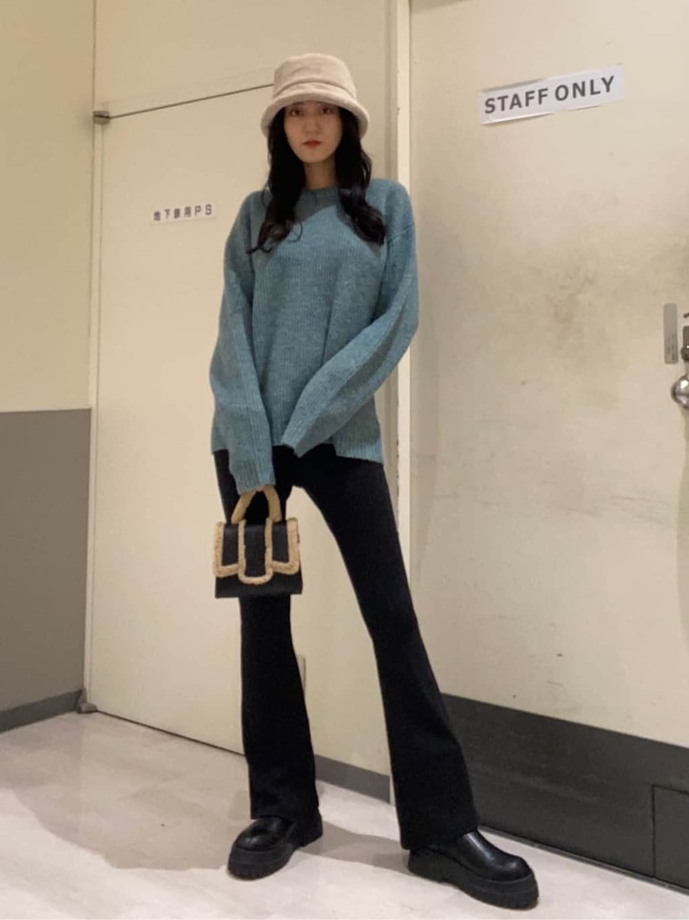 ブラック系のハンドバッグ、ブルー系のニット/セーター、ブラック系のその他パンツを着用したレディースの秋コーディネートの1枚目の写真