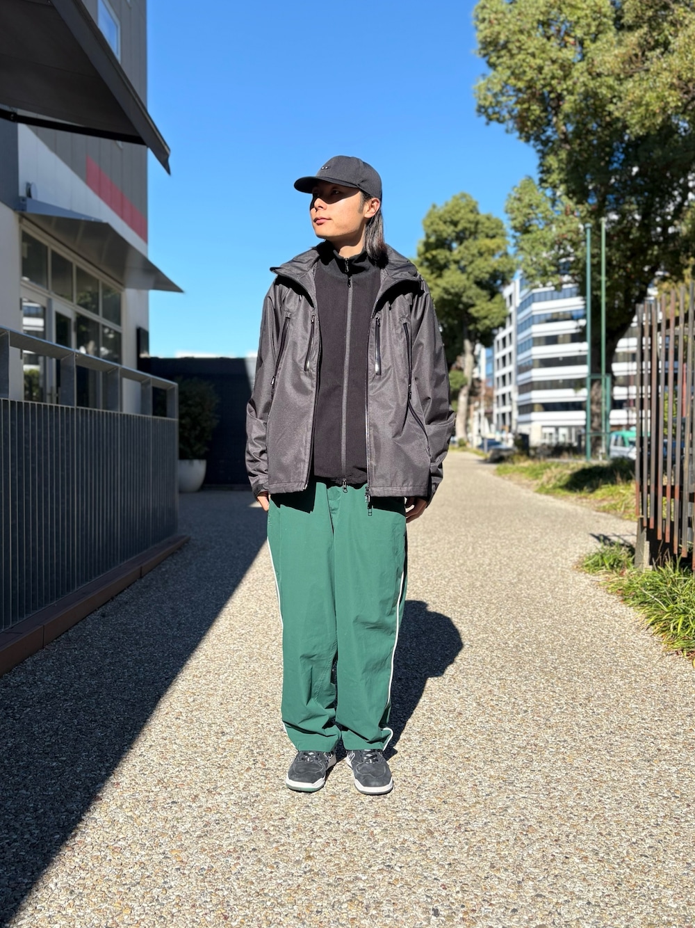 ブラック系のマウンテンパーカー、ブラック系のブルゾン、ブラック系のキャップを着用したメンズの秋コーディネートの1枚目の写真