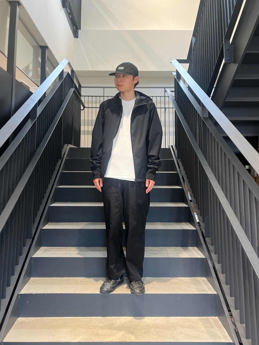 ブラック系のマウンテンパーカー、ホワイト系のTシャツ/カットソーを着用したメンズの春コーディネートの1枚目の写真